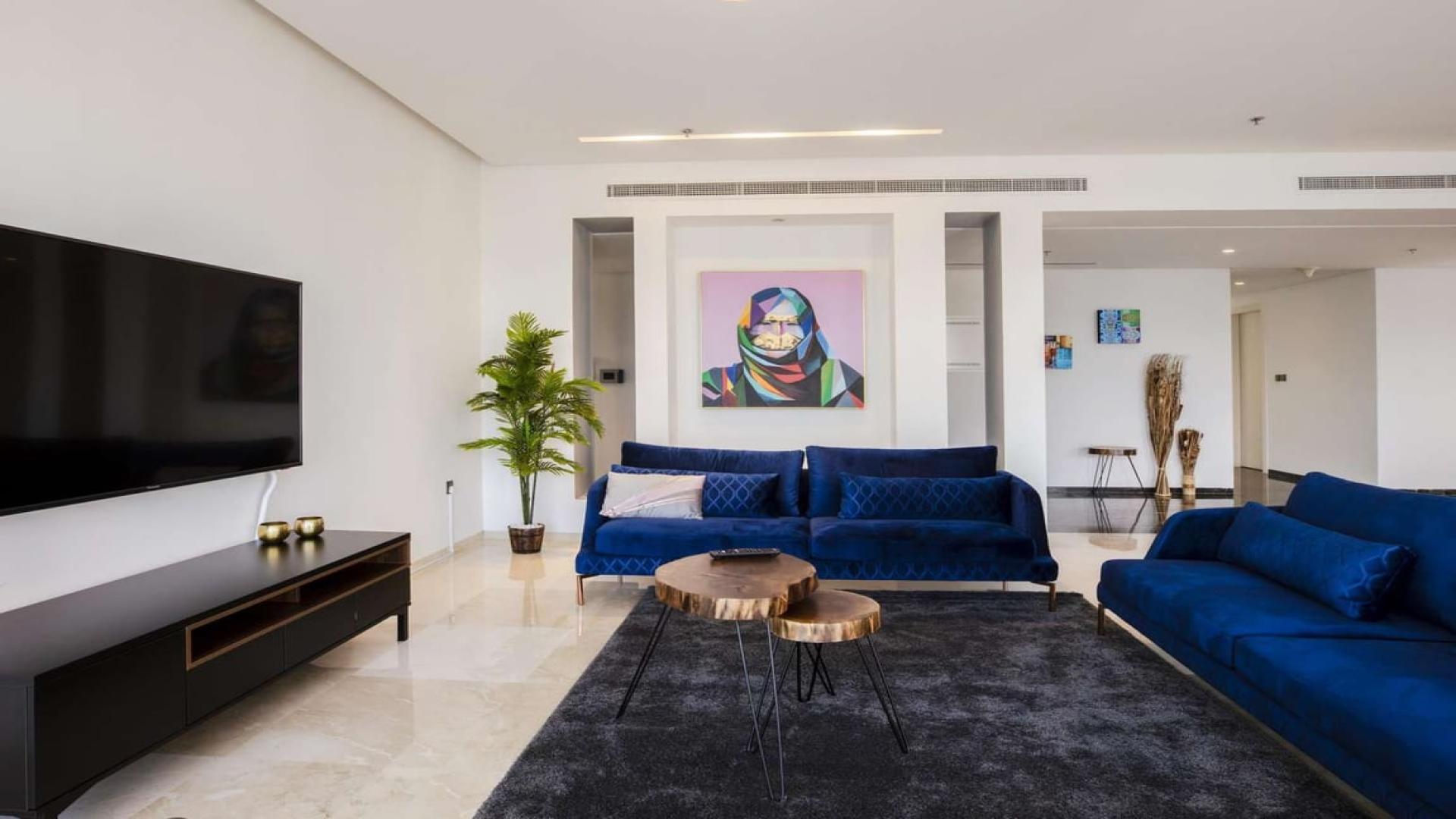 Modern living room in Dubai Marina penthouse with skyline mural and stylish furniture