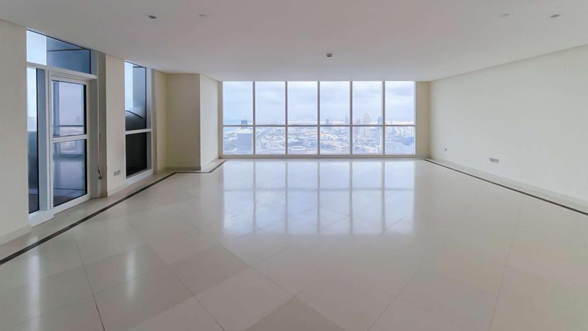 Open-plan penthouse living area with large windows and city views in Dubai Marina