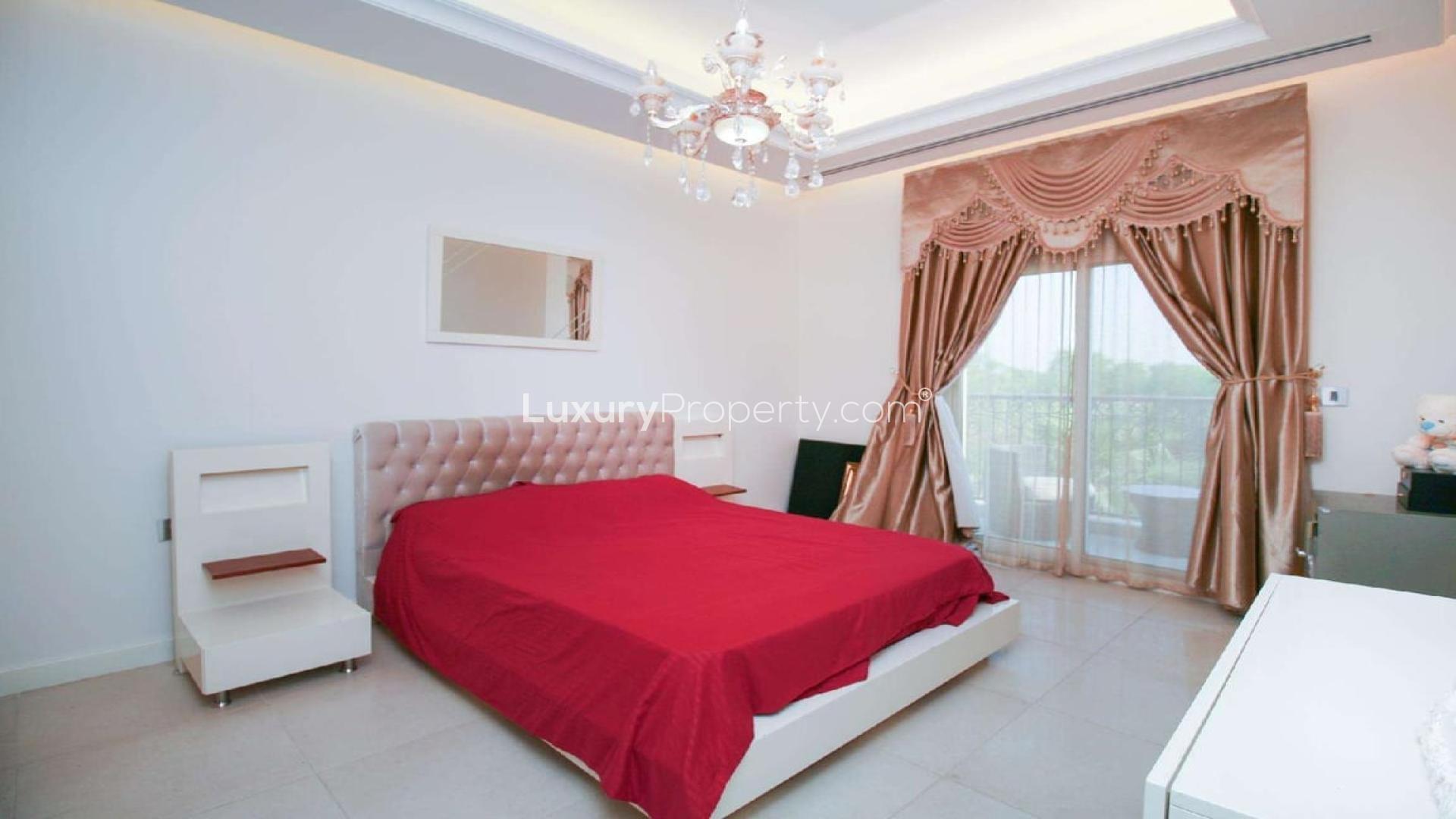 Elegant townhouse exterior in Redwood Park, Jumeirah Golf Estates, with two cars parked outside