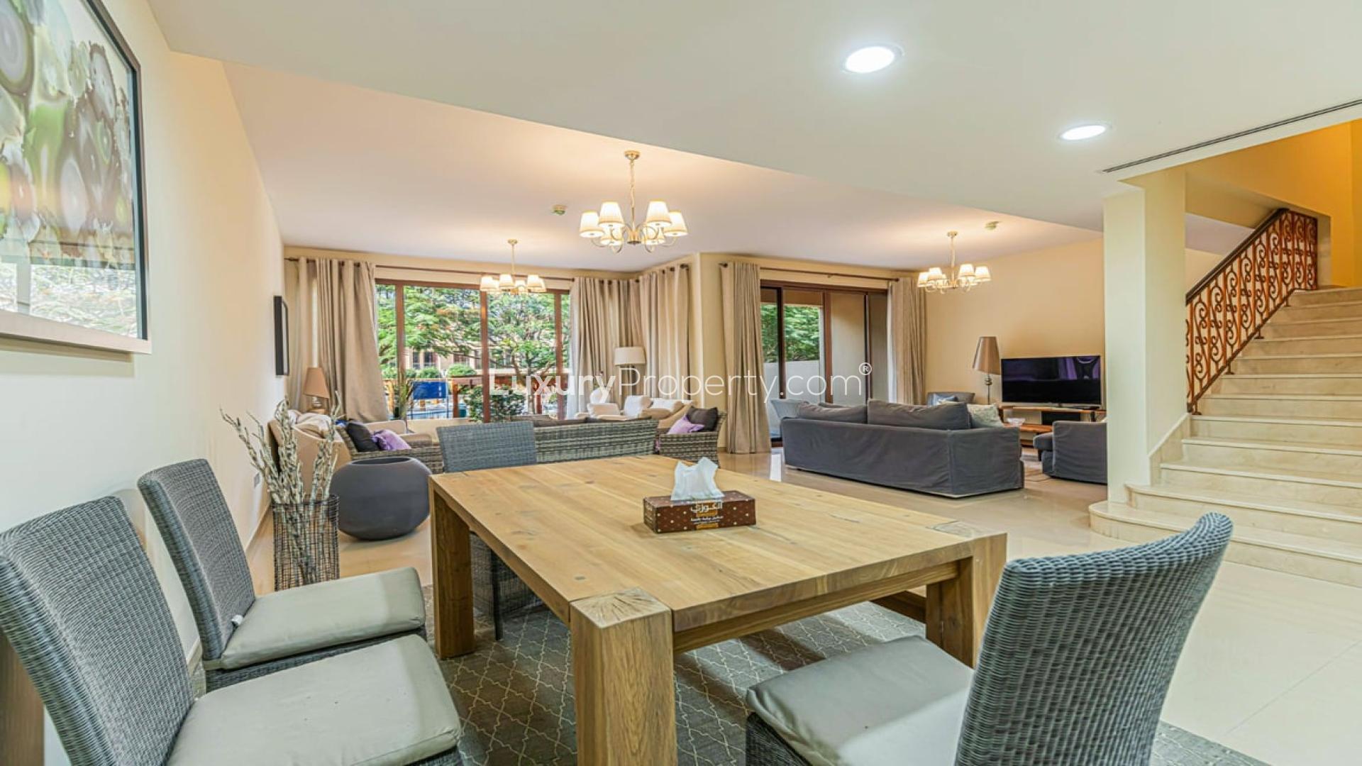 Luxurious living room in 4-bedroom townhouse, Jumeirah Islands, featuring elegant furnishings and garden view