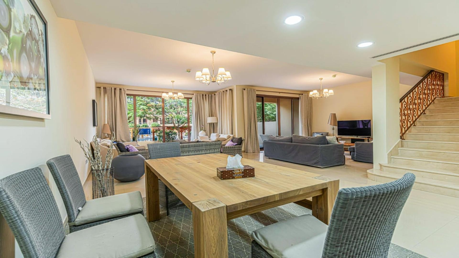 Luxurious living room in 4-bedroom townhouse, Jumeirah Islands, featuring elegant furnishings and garden view