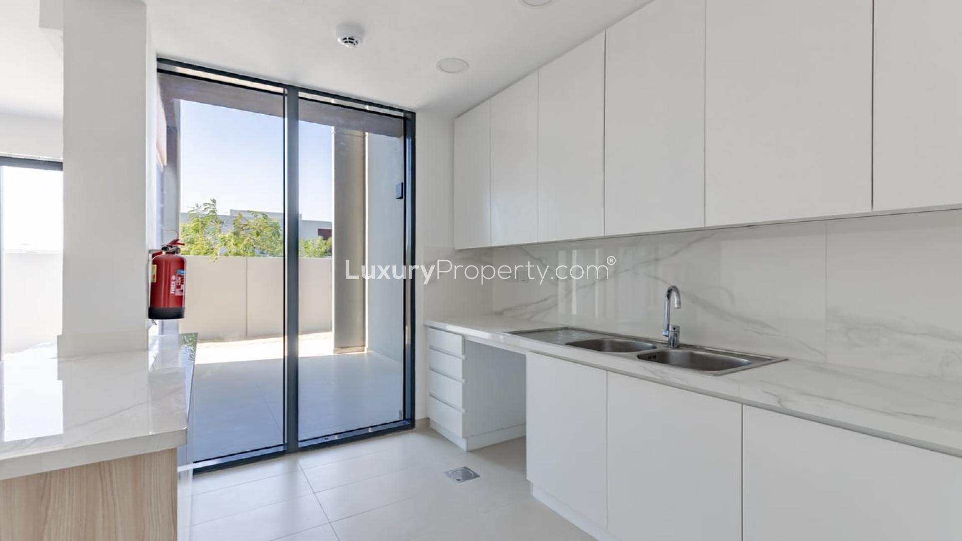 Modern kitchen in Cherrywoods townhouse, Dubai Land, with sleek cabinets and large window