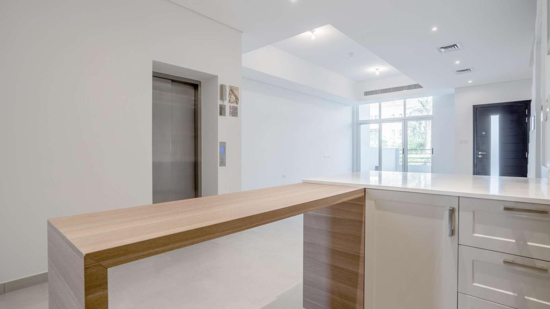 Modern kitchen in Somerset townhouse, Jumeirah Village Circle, featuring sleek design and natural light