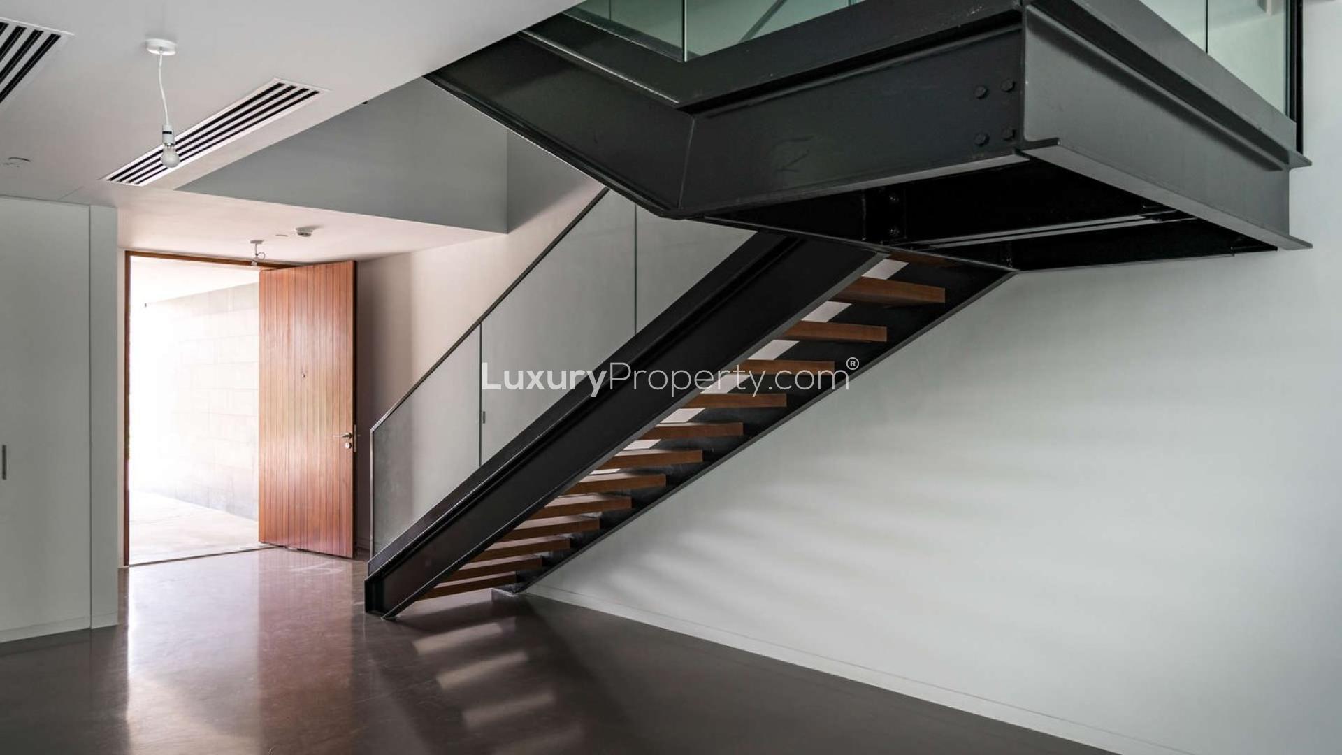 Exterior view of luxury townhouse at Nikki Beach, Pearl Jumeirah, with lush green landscaping