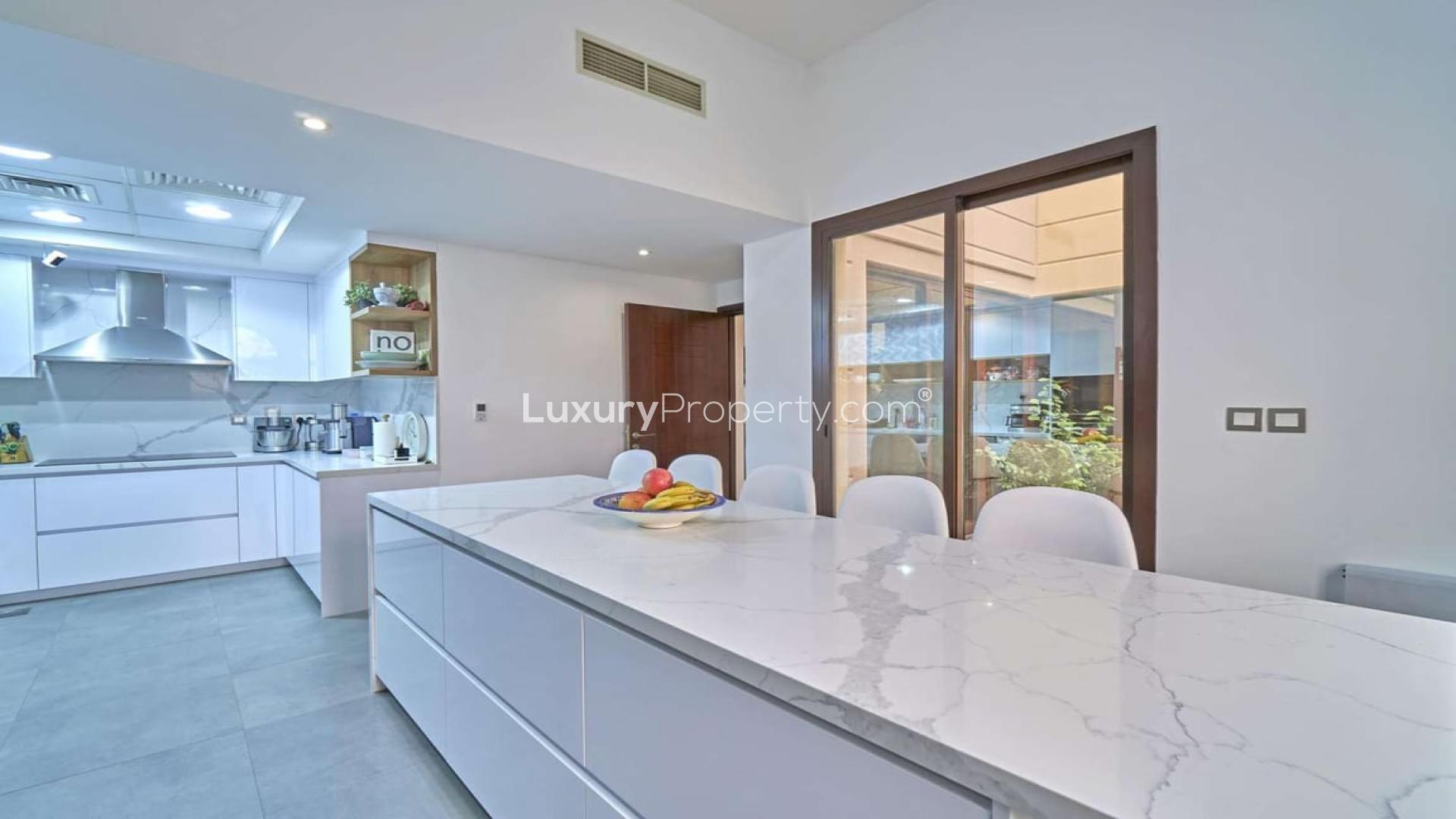 Stunning 4-bedroom townhouse exterior in Al Naseem, Mudon with driveway and parked cars