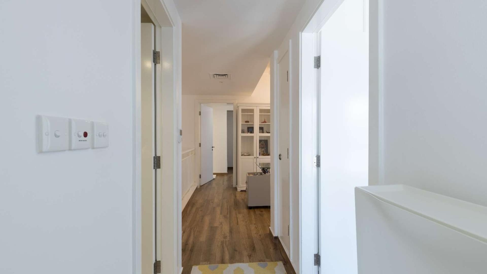 "Bright hallway in upgraded Springs 3 townhouse, featuring wooden floors and white doors.","Charming townhouse patio with lush greenery in Springs 3, The Springs community.",Modern bathroom in upgraded Springs 3 townhouse with sleek fixtures and glass shower