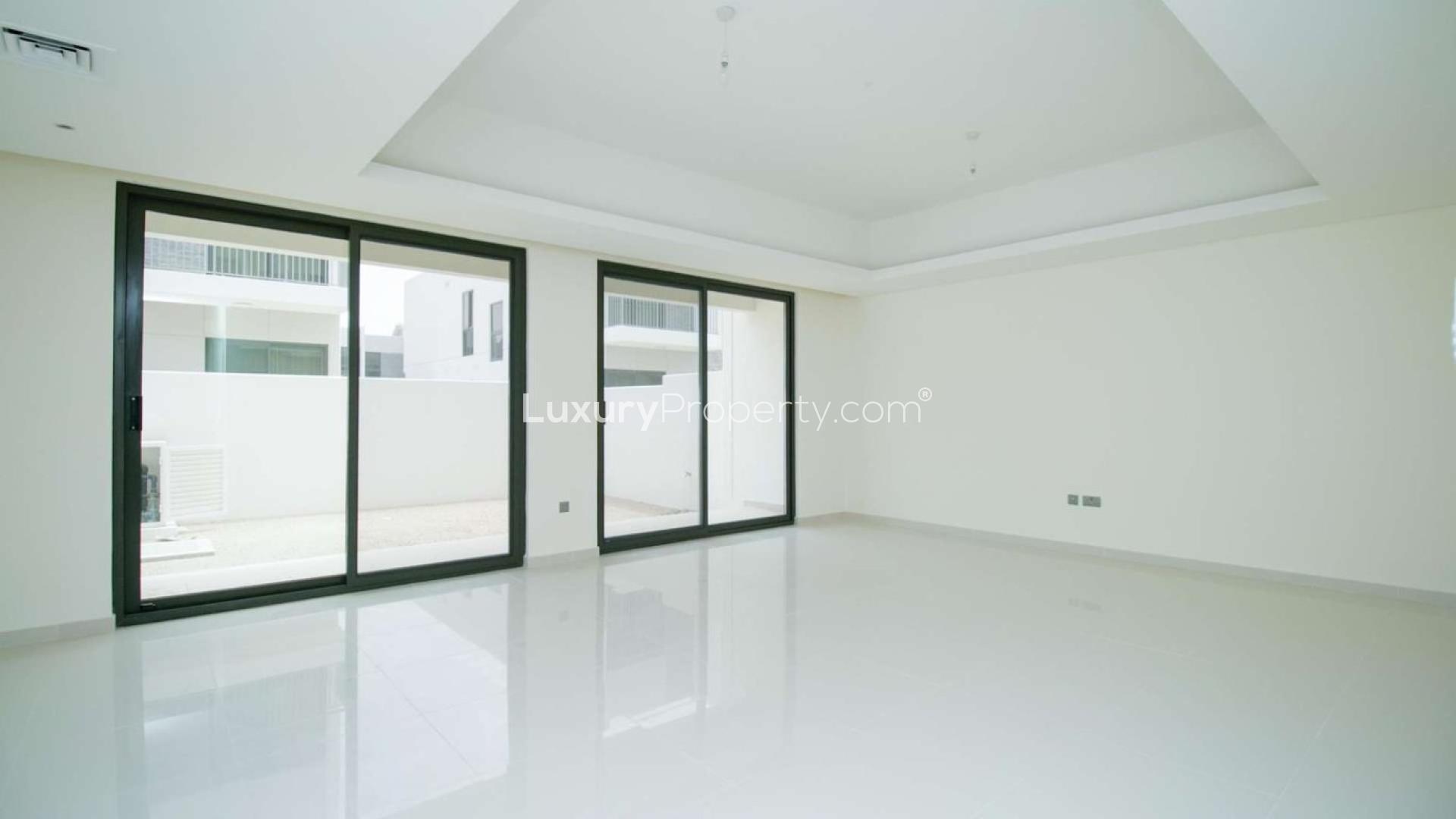 Four-bedroom townhouse exterior in Claret, Damac Hills 2, for sale. Modern design, spacious driveway