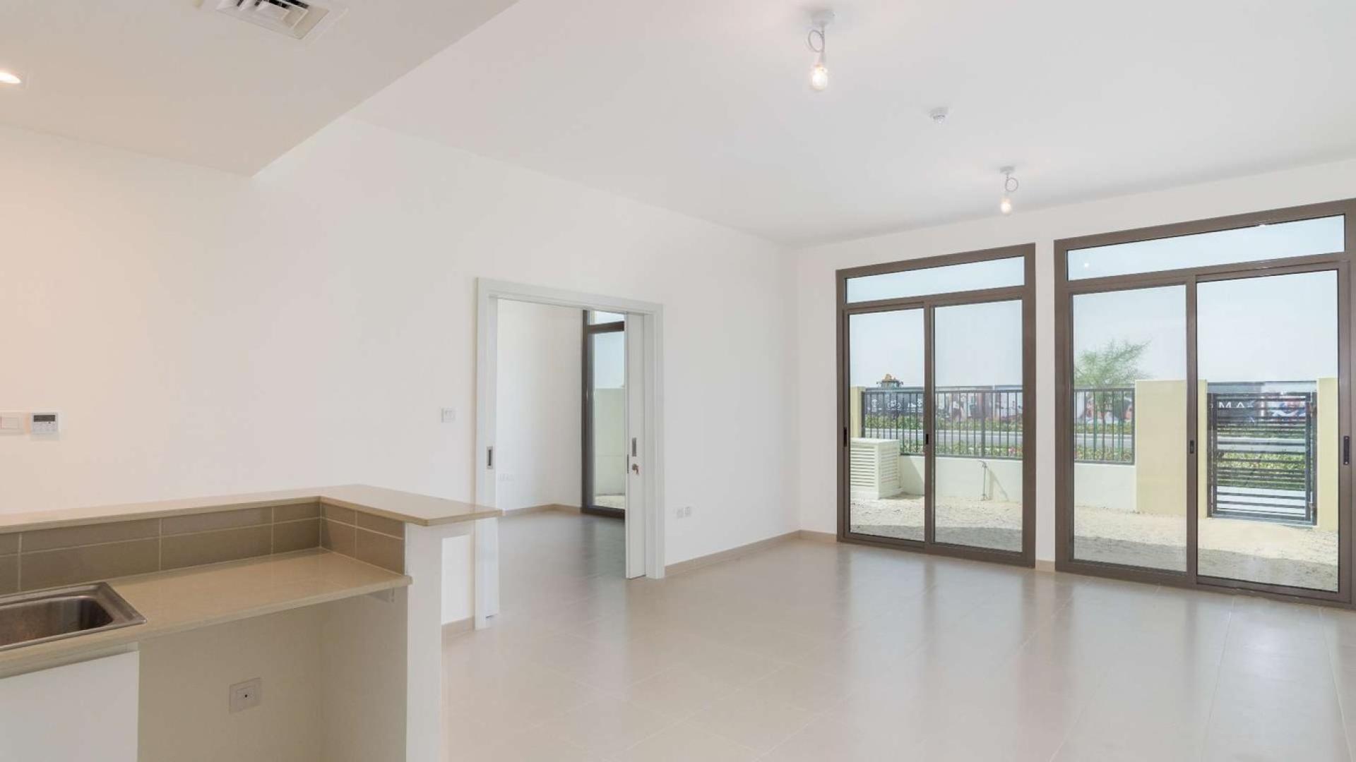 Four-bedroom townhouse exterior in Naseem Community, Town Square Dubai, with carport and garden