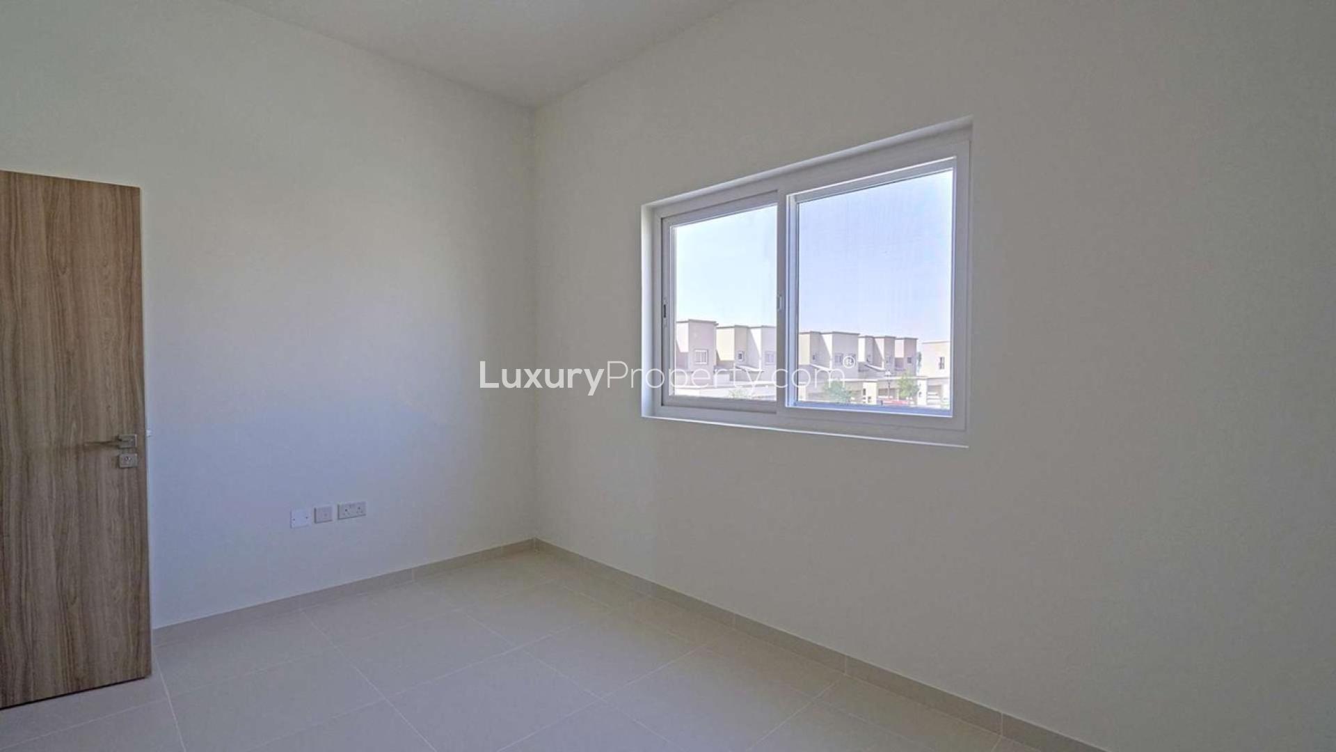 Townhouse exterior in Villanova, Dubai Land, with driveway and garden. Ref: LP08456