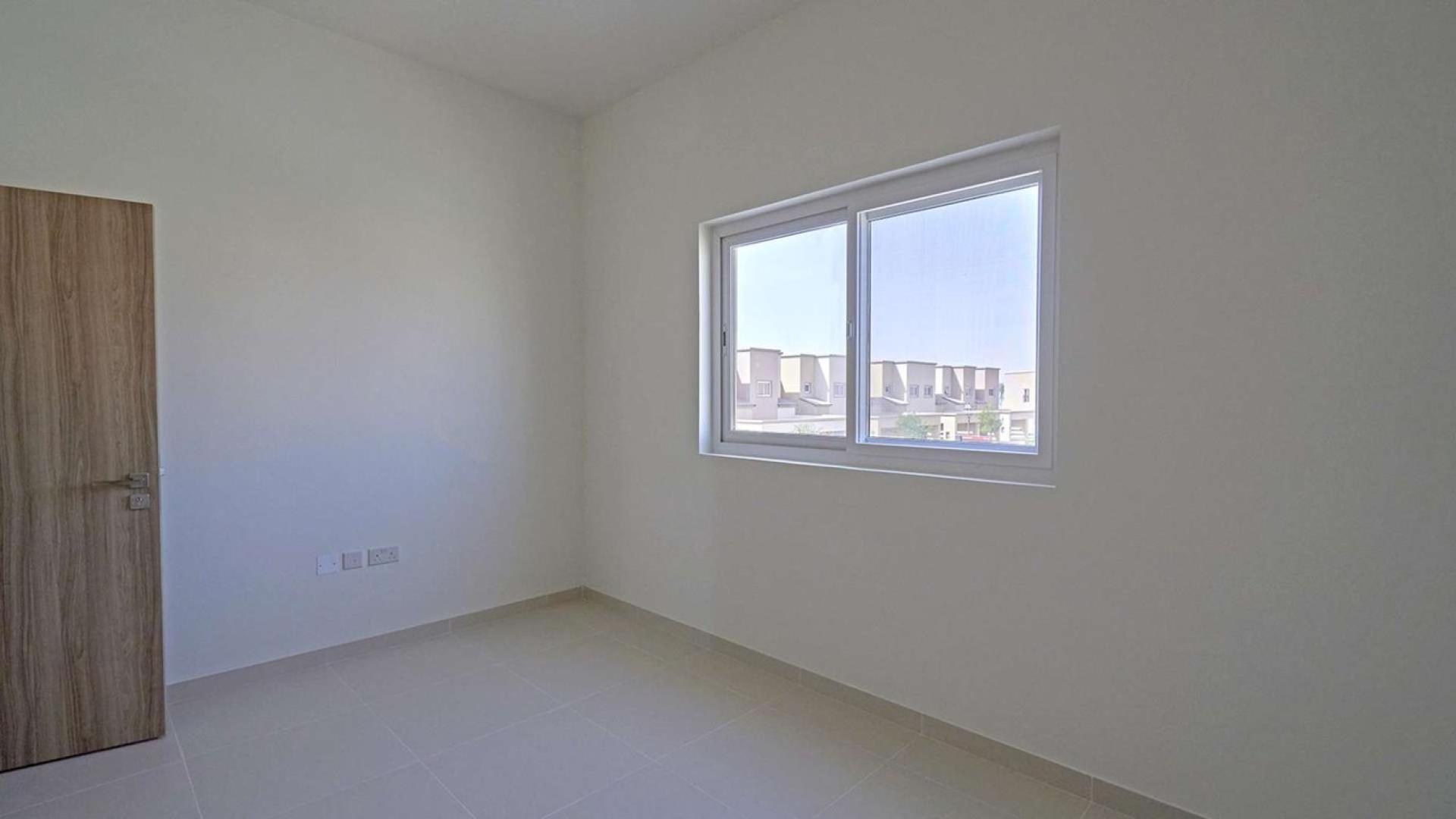 Townhouse exterior in Villanova, Dubai Land, with driveway and garden. Ref: LP08456