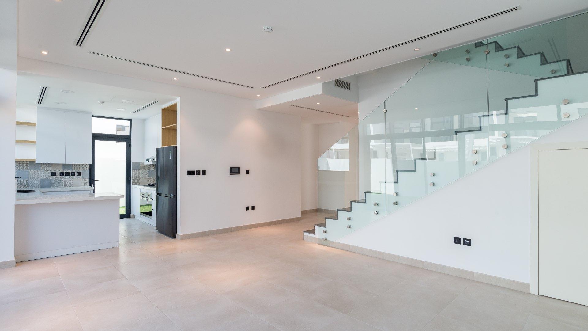 "Modern townhouse exterior with spacious garden in Jumeirah Luxury, Jumeirah Golf Estates.",Modern kitchen and staircase in Jumeirah Luxury townhouse, Flower Villa for sale