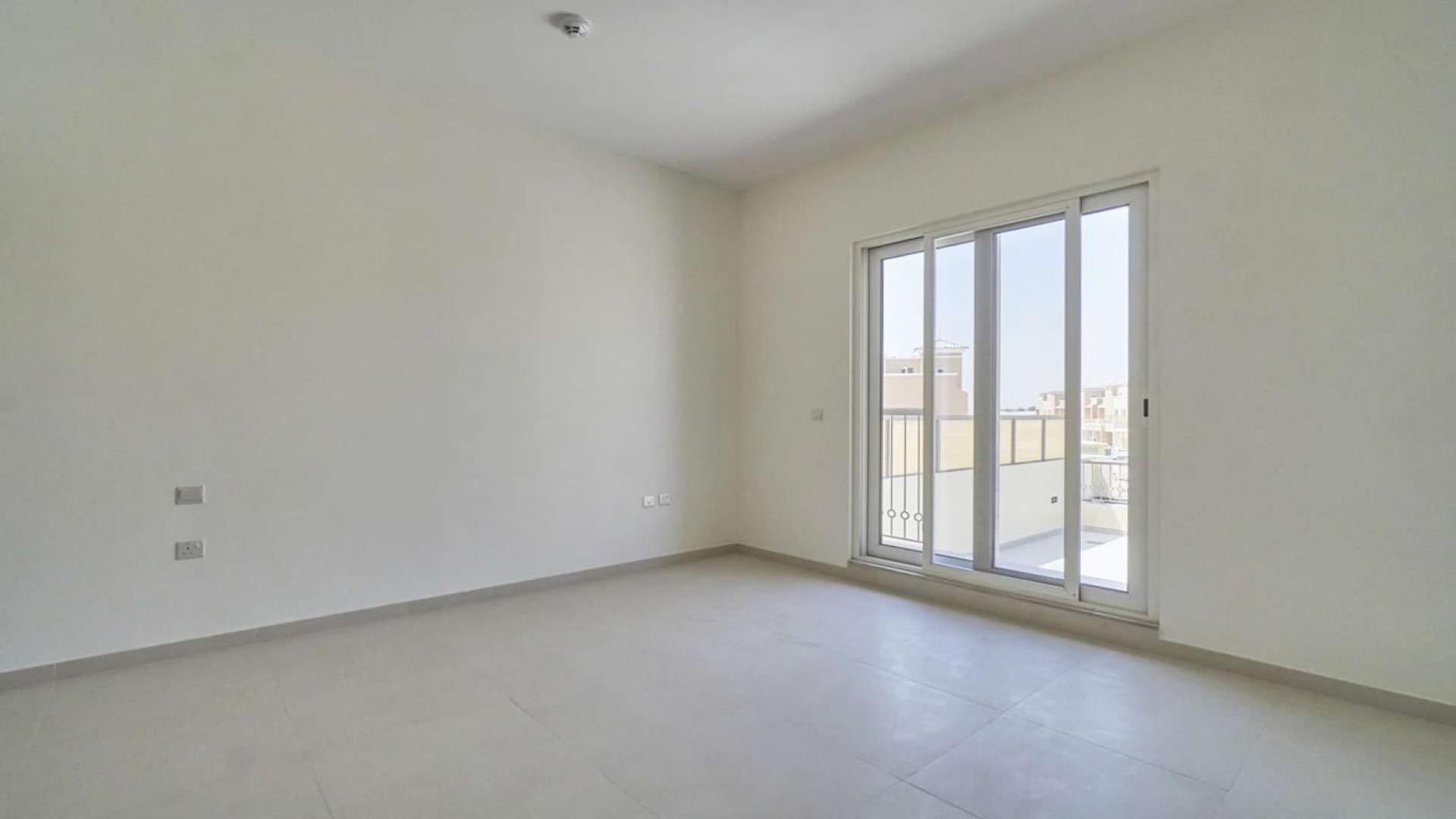 Spacious bedroom with balcony access in 4-bed townhouse, Victory Heights, Dubai Sports City