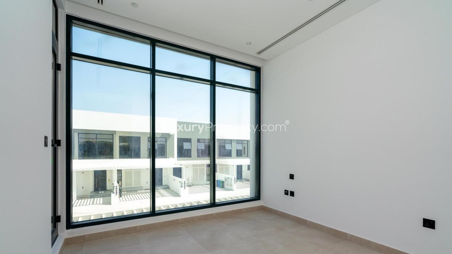 "Spacious townhouse balcony with golf course view in Jumeirah Golf Estates, for sale.","Spacious townhouse interior with large windows in Jumeirah Golf Estates, overlooking luxury homes.",Modern kitchen and staircase in Jumeirah Golf Estates townhouse, LP11792 for sale