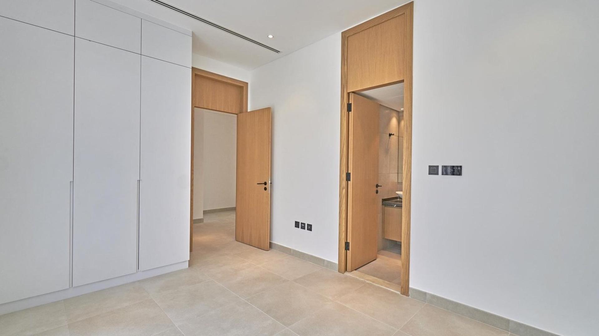 Modern open-plan kitchen and staircase in Jumeirah Golf Estates townhouse for sale