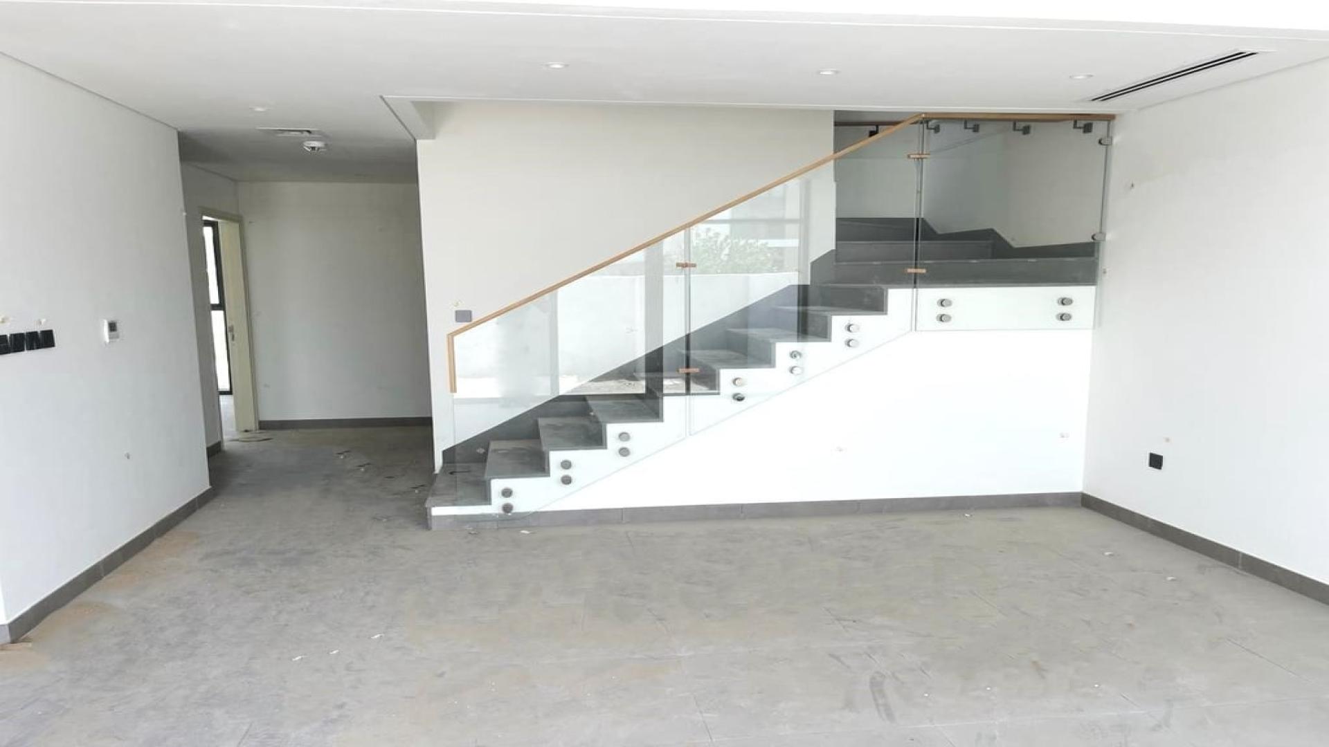 Modern townhouse community path in Arabian Ranches 3, Ruba, featuring landscaped gardens