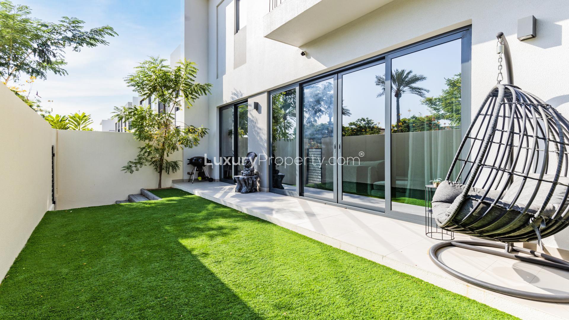 "Arabian Ranches 2 Camelia townhouse garden with patio and seating area for sale.","Spacious backyard with patio and hanging chair in Camelia townhouse, Arabian Ranches 2, for sale.",Modern living room with upgraded kitchen in Camelia townhouse, Arabian Ranches 2, for sale