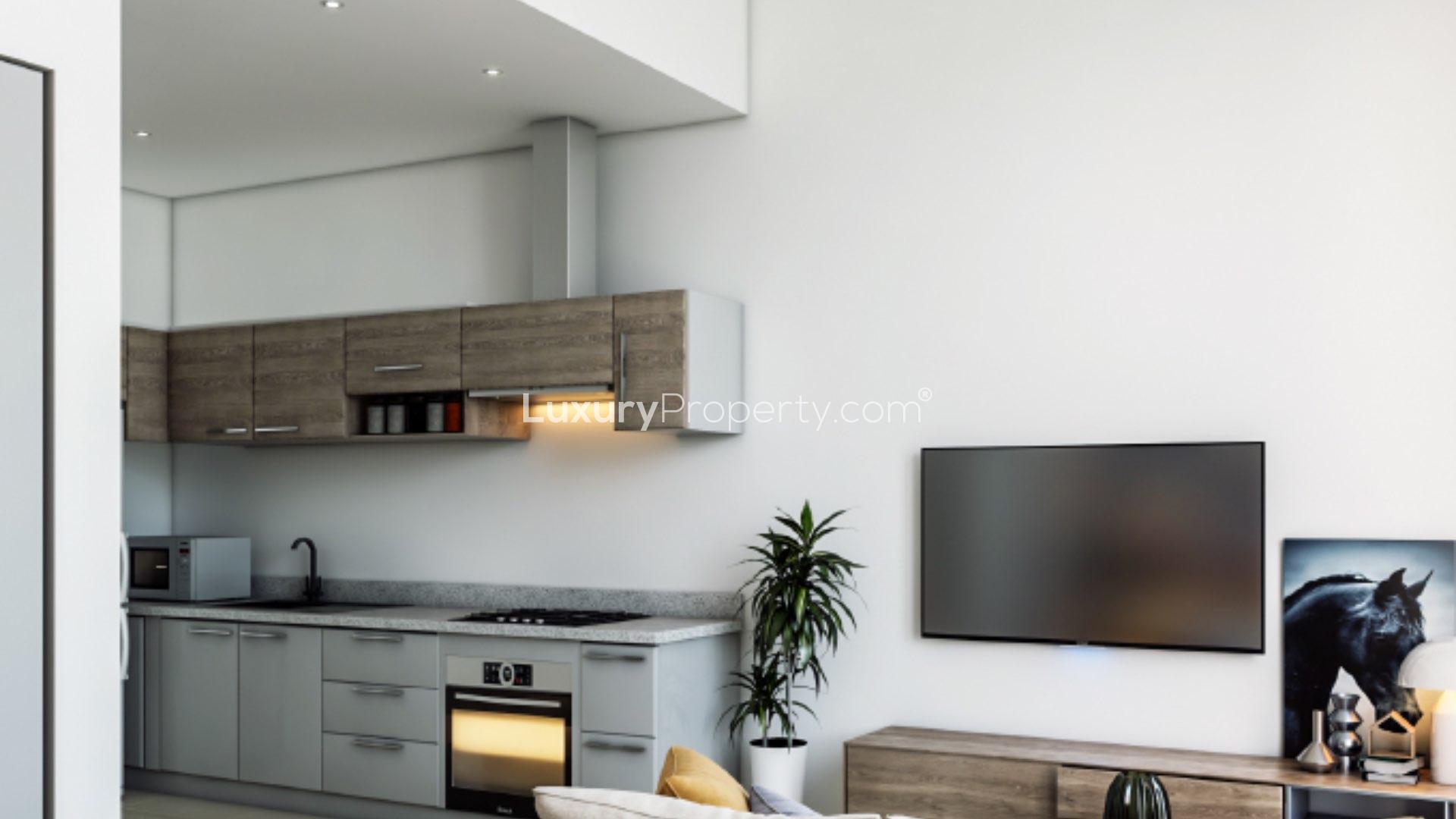 Modern bedroom with cozy sofa, vibrant pillows, and garden view at Muscat Hills townhouse