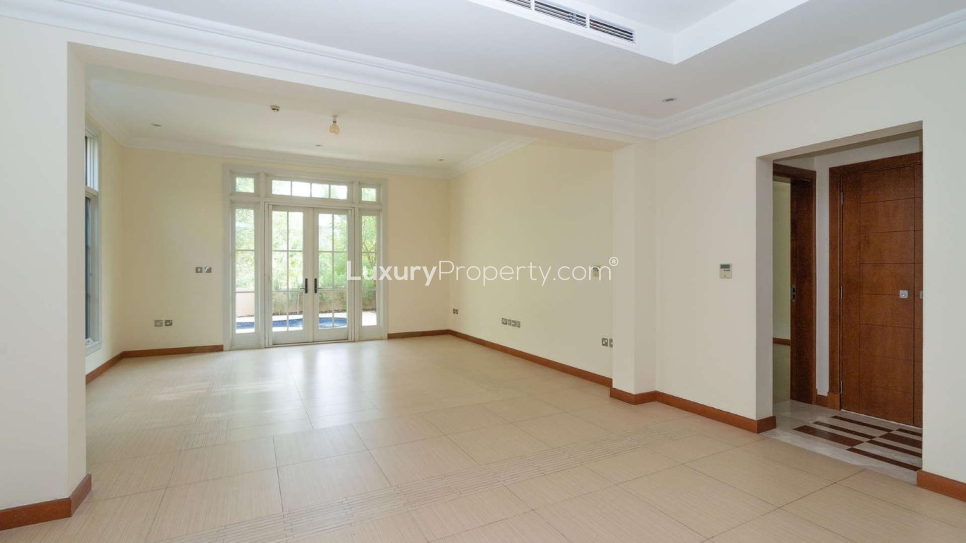 "Elegant villa exterior at Whispering Pines, Jumeirah Golf Estates, lush garden, for sale.",Stunning villa exterior with wooden garage, lush greenery, Jumeirah Golf Estates, Earth community