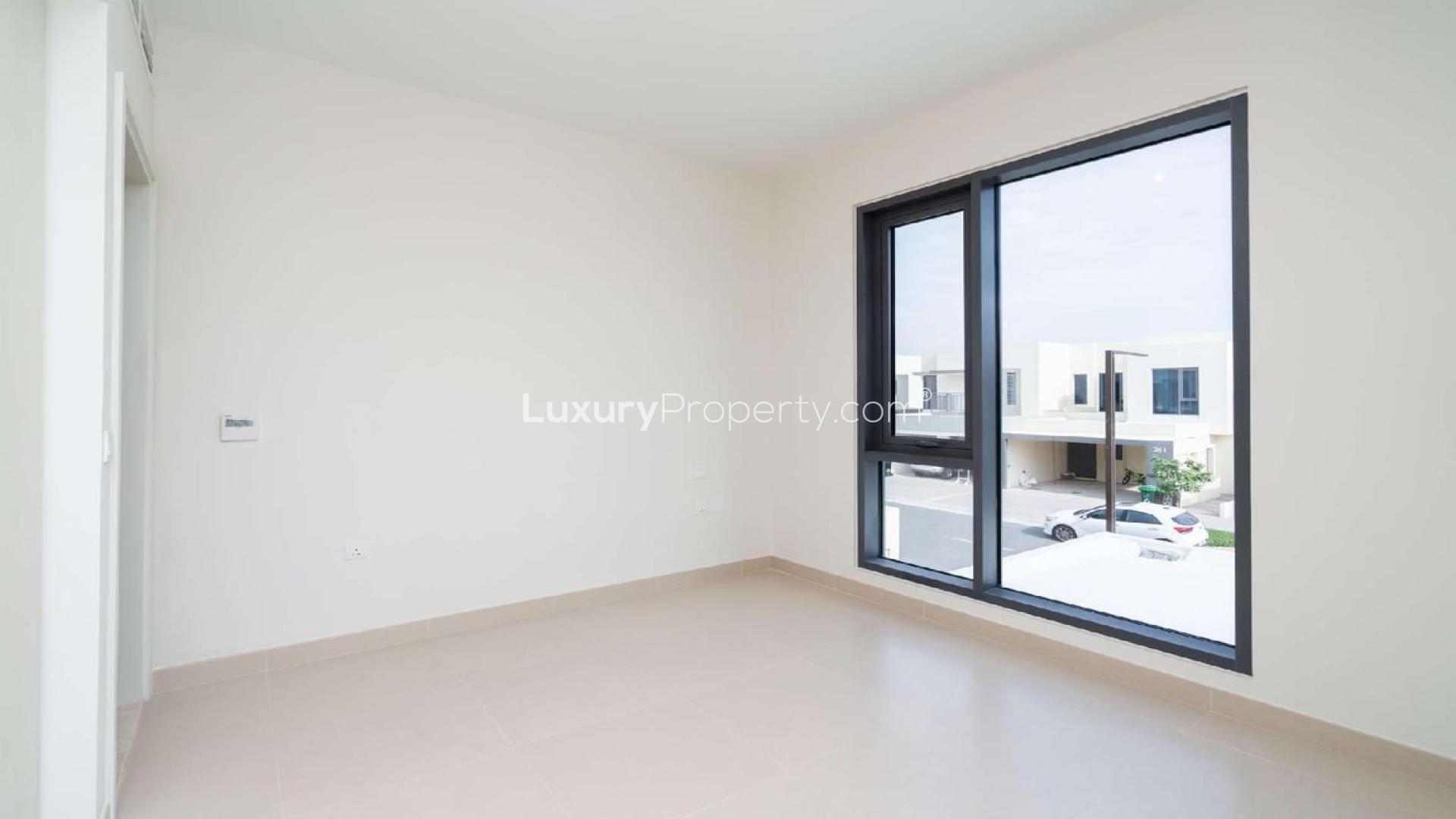 Modern living room with large windows, overlooking landscaped garden in Dubai Hills Estate townhouse