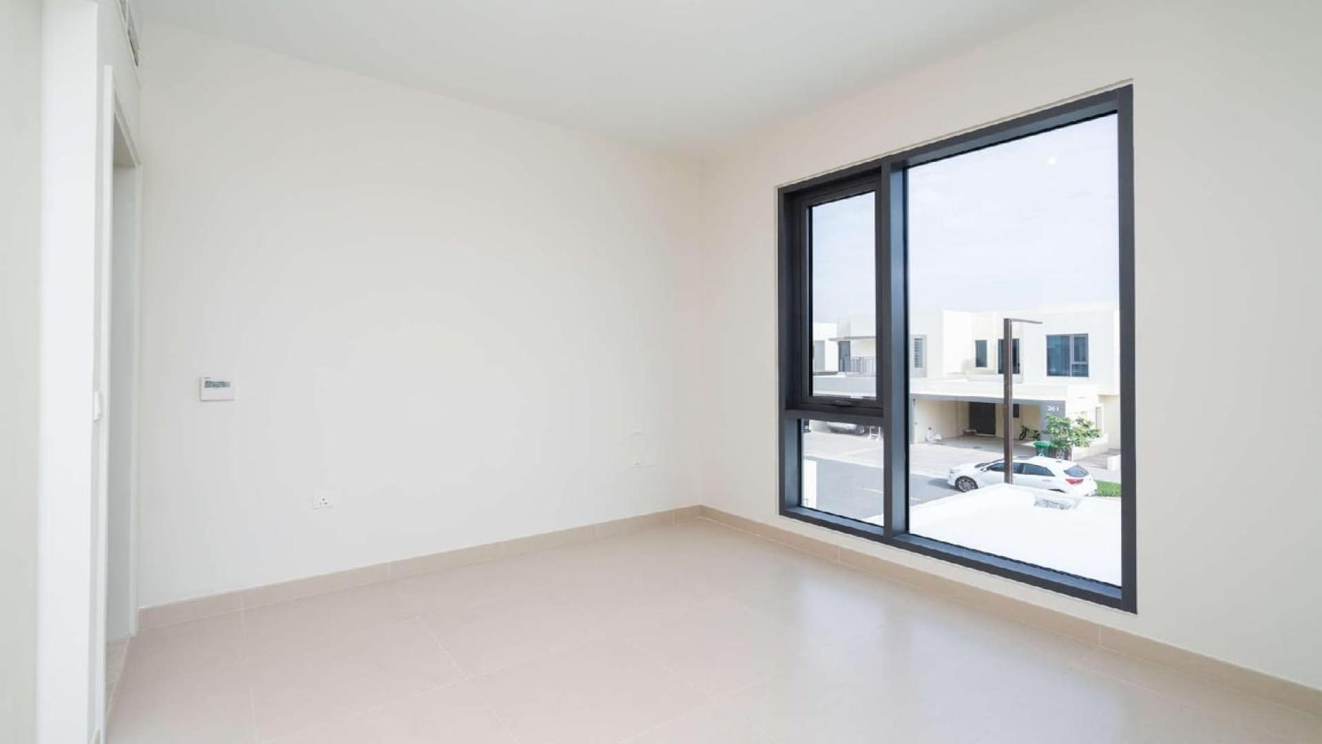 Modern living room with large windows, overlooking landscaped garden in Dubai Hills Estate townhouse