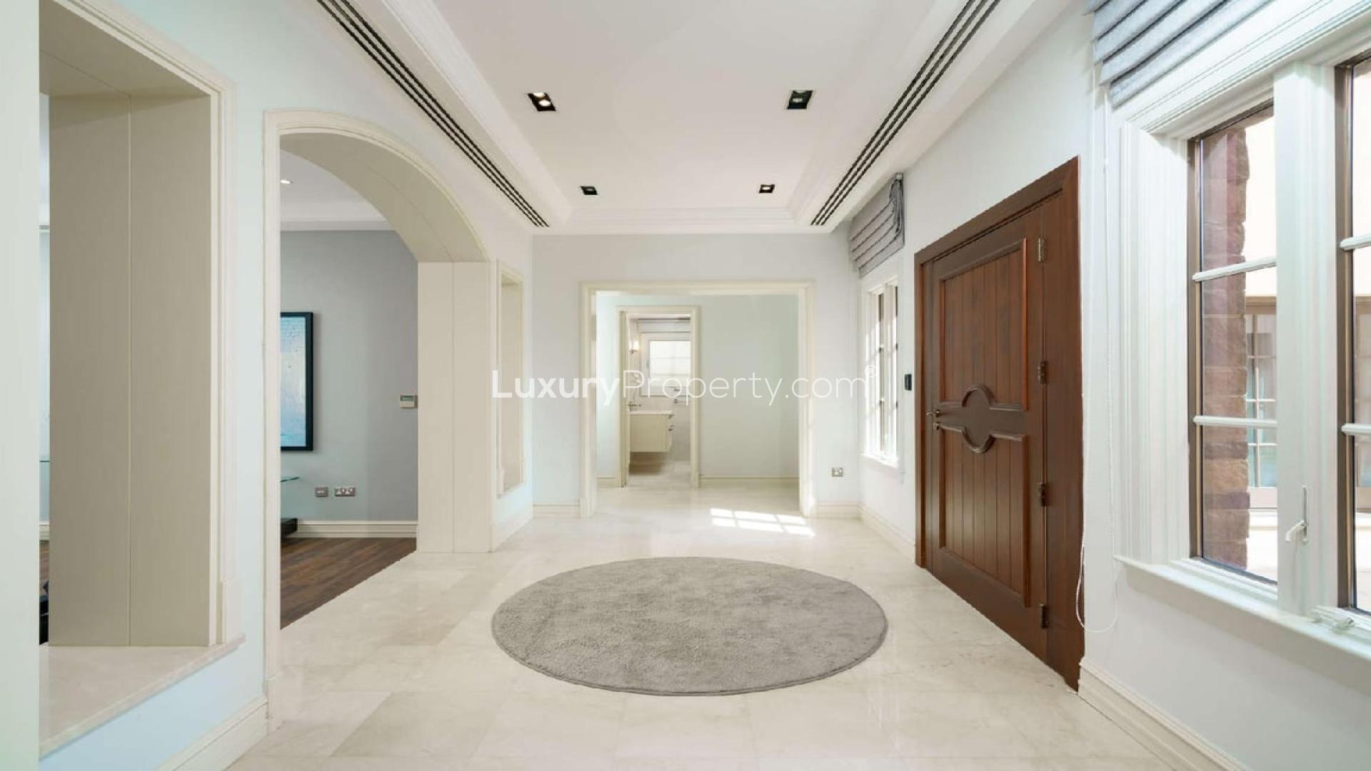 Luxurious living room in Mediterranean-style villa, Jumeirah Golf Estates, with elegant furnishings and garden view