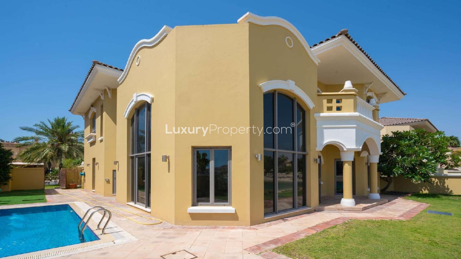 Spacious living room with large windows and pool view in Palm Jumeirah villa for rent