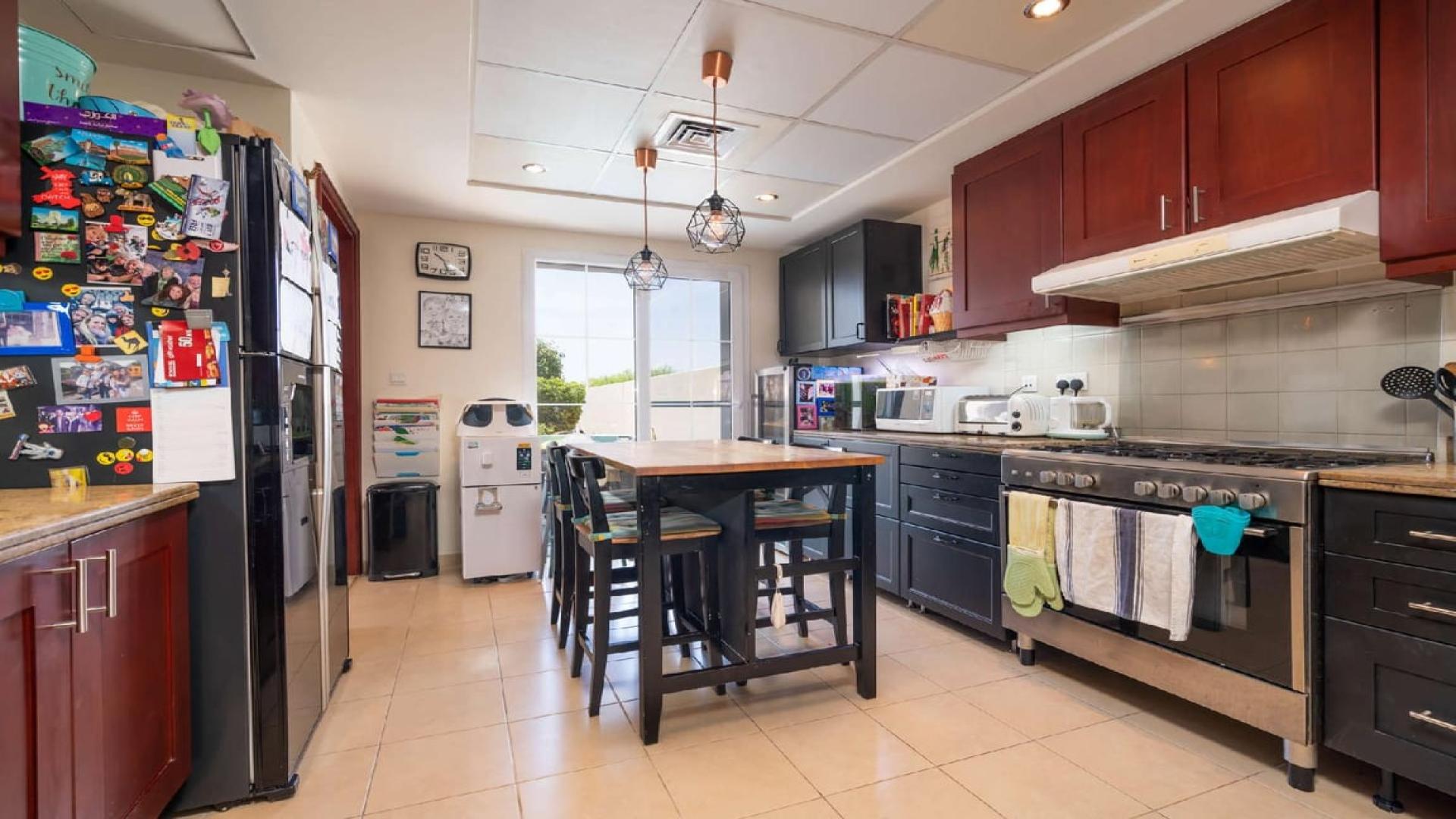 Dining area in 4-bedroom townhouse, Alma, Arabian Ranches with garden view and stylish decor