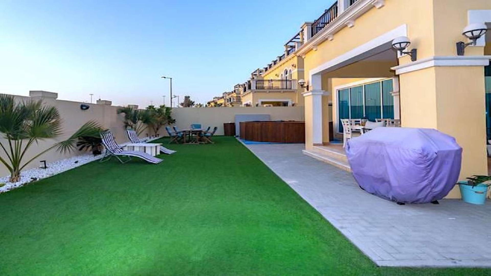 "Elegant 4-bedroom Legacy Nova Villa exterior in Jumeirah Park, available for rent.",Spacious backyard with lawn and patio in Jumeirah Park Legacy Nova Villa for rent