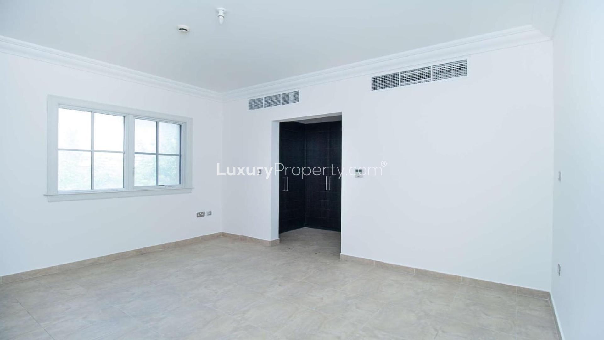 Gorgeous villa exterior in Whispering Pines, Jumeirah Golf Estates, with stone accents and greenery