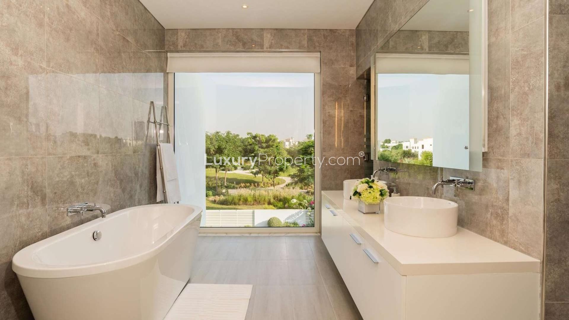 Modern 4-bedroom villa exterior in The Nest, Al Barari, with lush greenery and garage