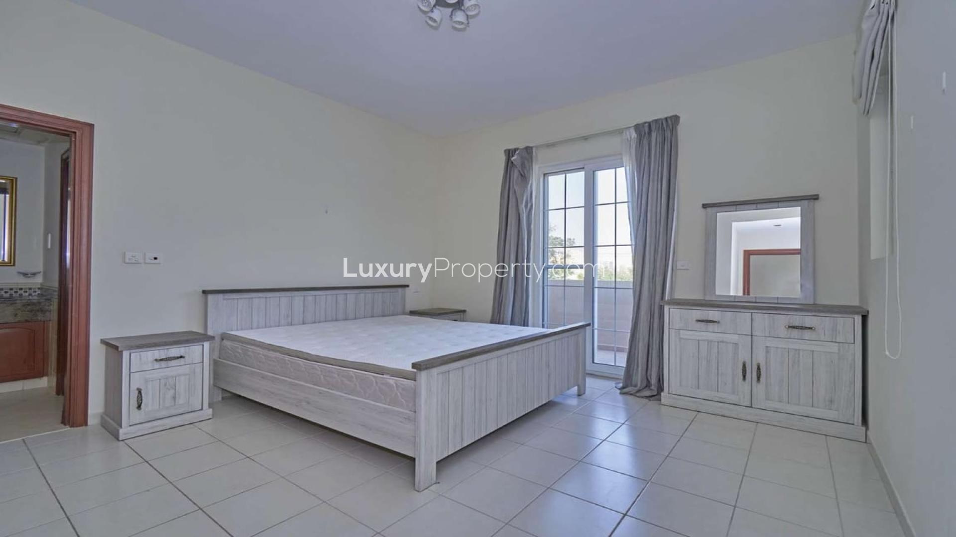 "View from villa balcony overlooking pool and garden in Mirador La Coleccion, Arabian Ranches.",4-bedroom villa bedroom with balcony in Mirador La Coleccion, Arabian Ranches for rent