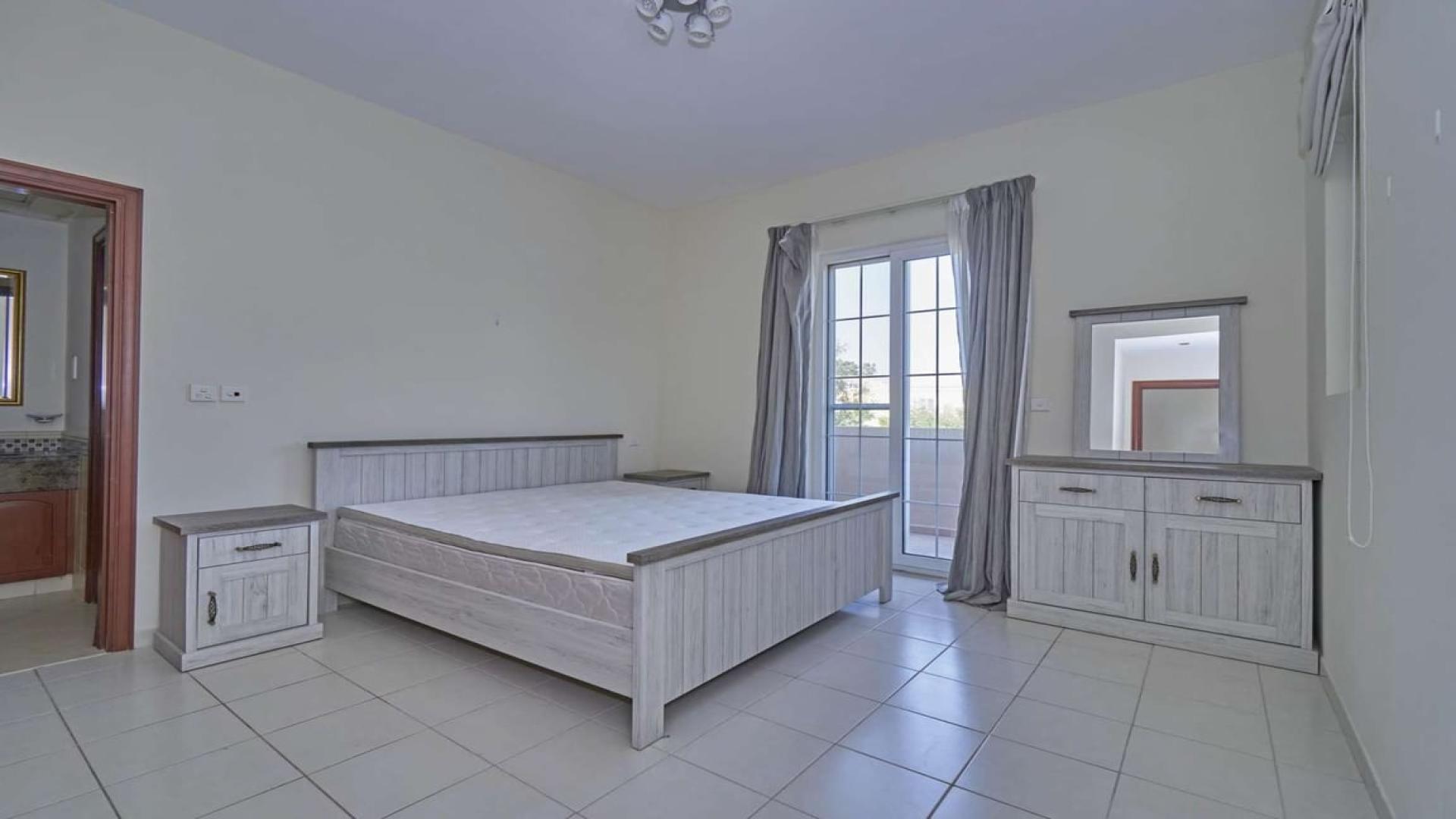 "View from villa balcony overlooking pool and garden in Mirador La Coleccion, Arabian Ranches.",4-bedroom villa bedroom with balcony in Mirador La Coleccion, Arabian Ranches for rent