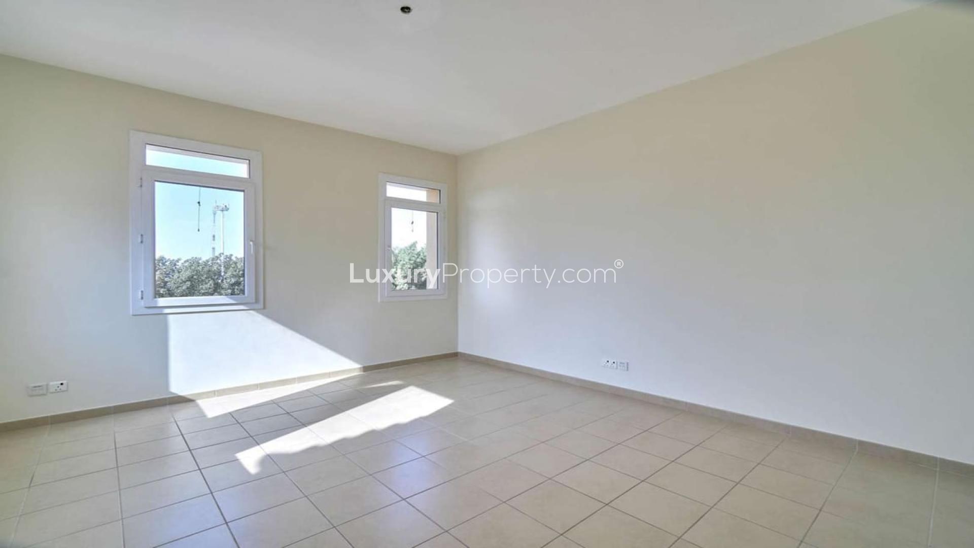 Empty sunlit room in Palmera villa, Arabian Ranches, with tiled floor and two windows