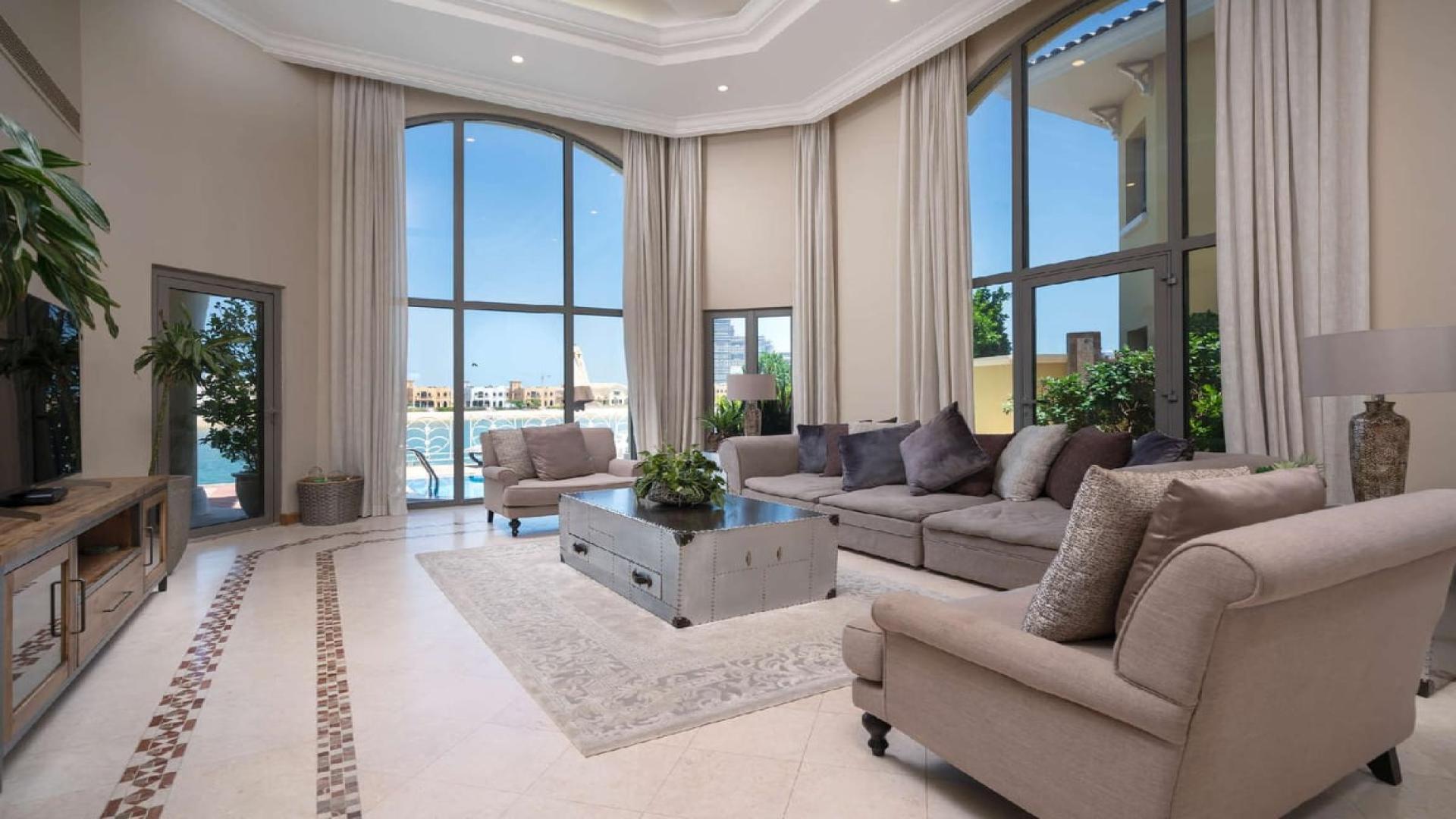 Luxurious living room in four-bedroom villa, Palm Jumeirah, with large windows and elegant decor