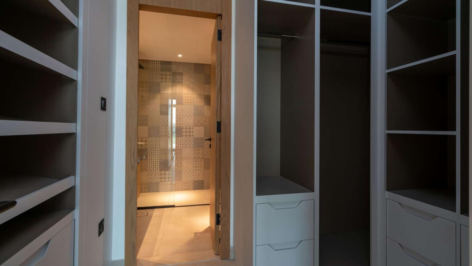 Elegant walk-in closet in Jumeirah Golf Estates villa for rent, featuring ample storage space