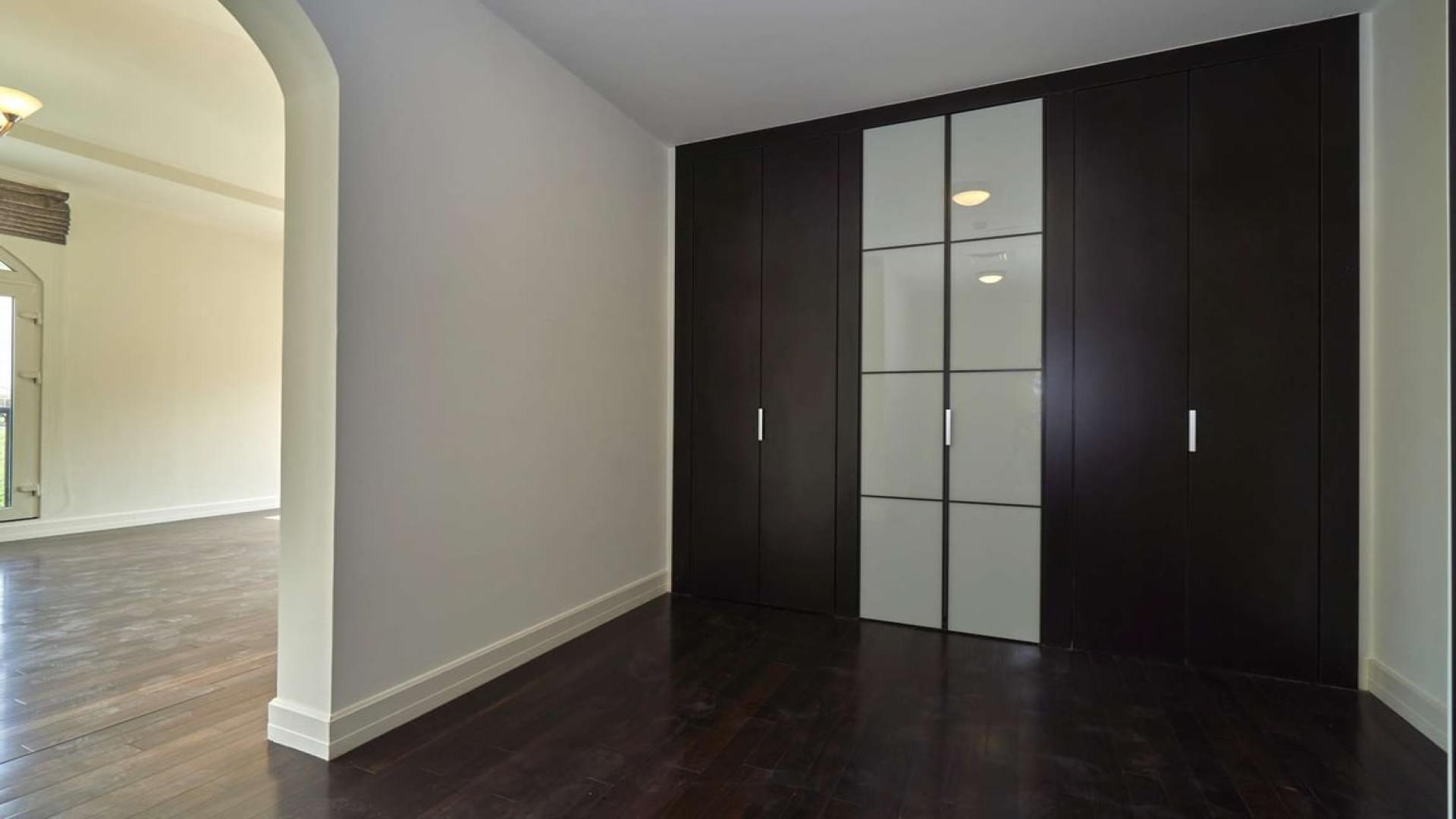Spacious villa interior with dark wood flooring and built-in wardrobe in Sienna Lakes