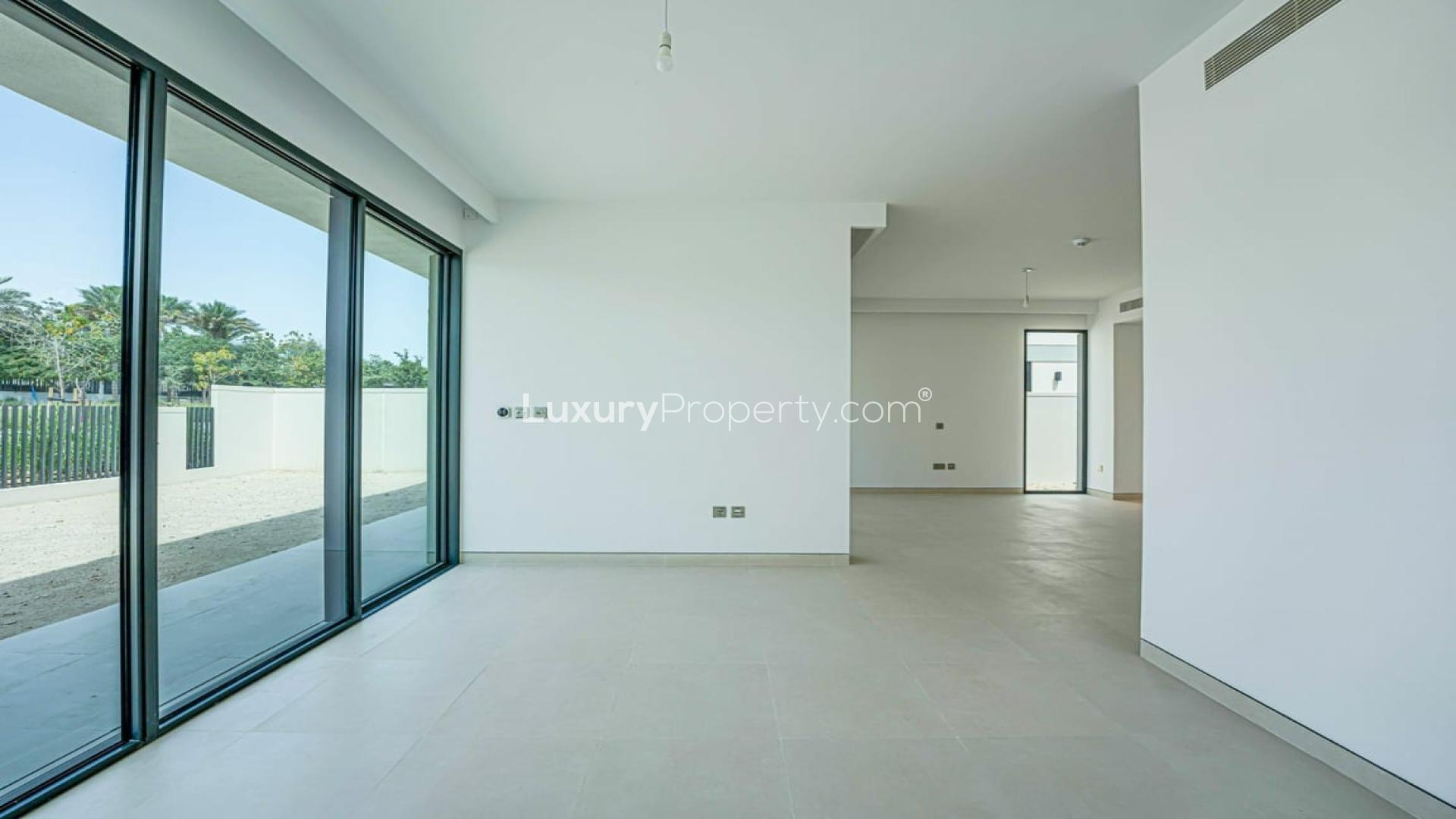 Empty living room with large windows in Tilal Al Ghaf Harmony villa for rent
