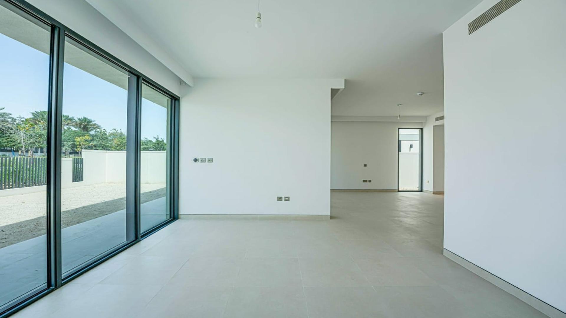 Empty living room with large windows in Tilal Al Ghaf Harmony villa for rent