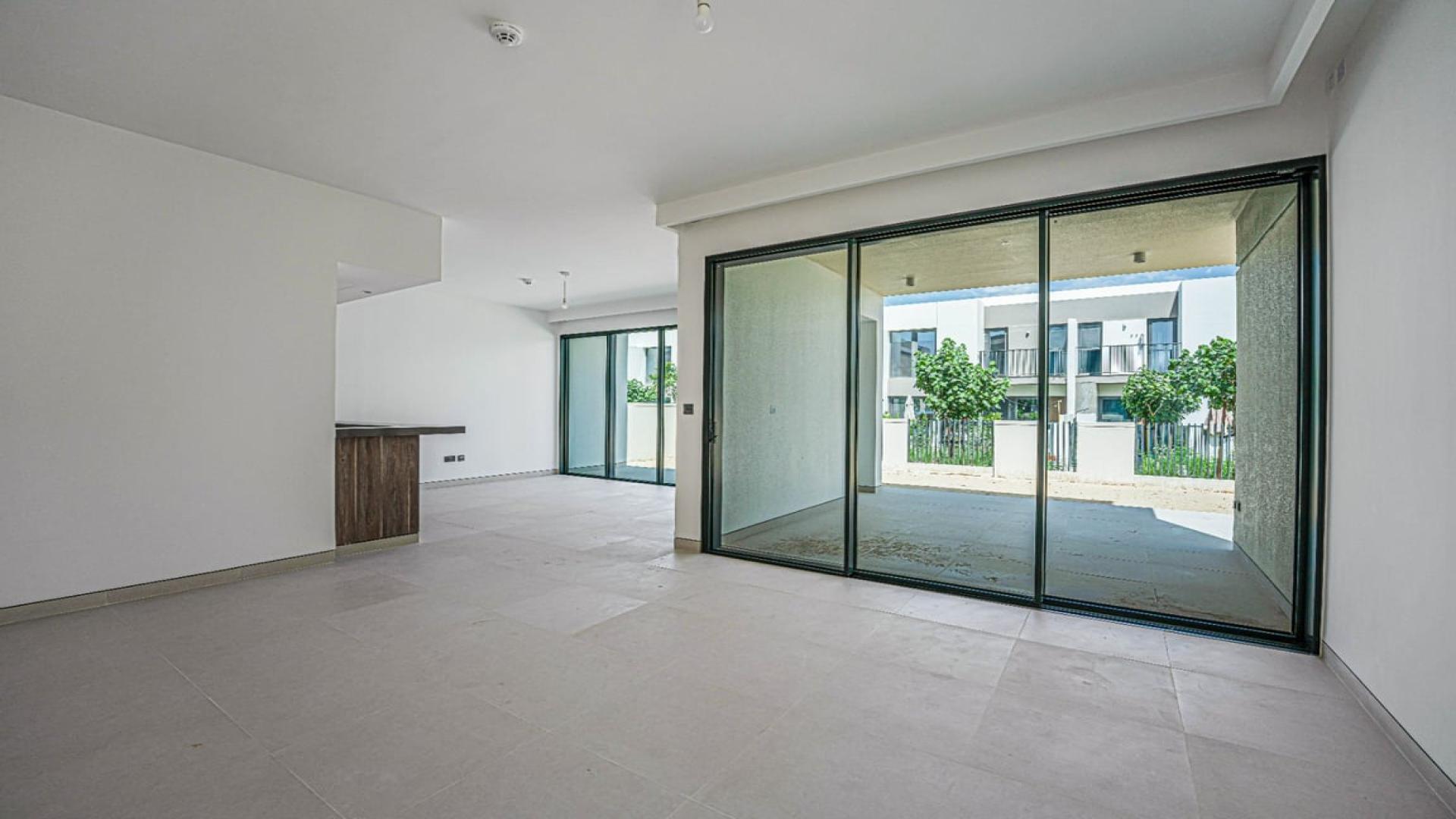 Spacious living room with large glass doors in Harmony Villa, Tilal Al Ghaf for rent