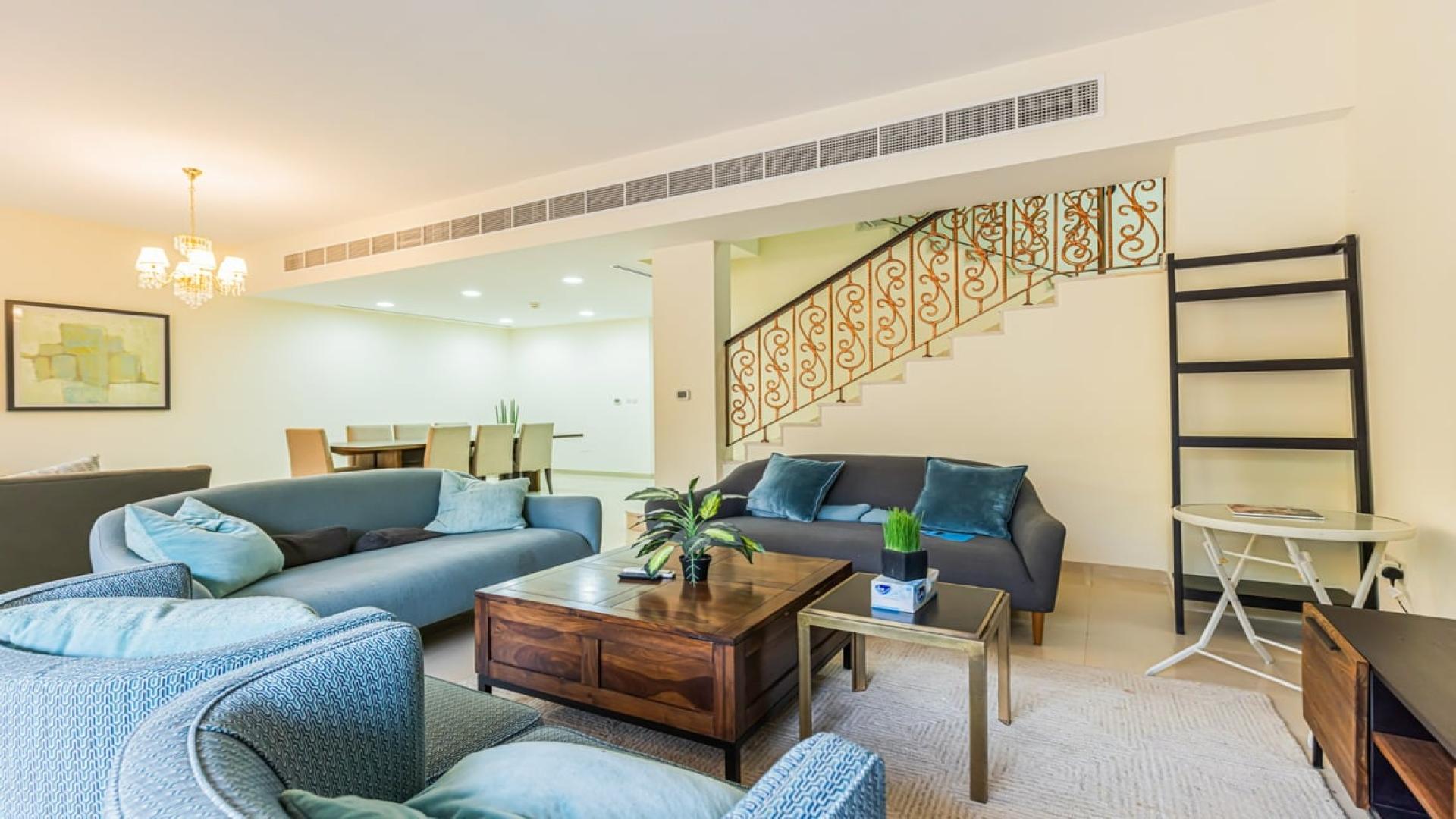 Furnished living area in Jumeirah Islands villa, bright with garden view, modern decor