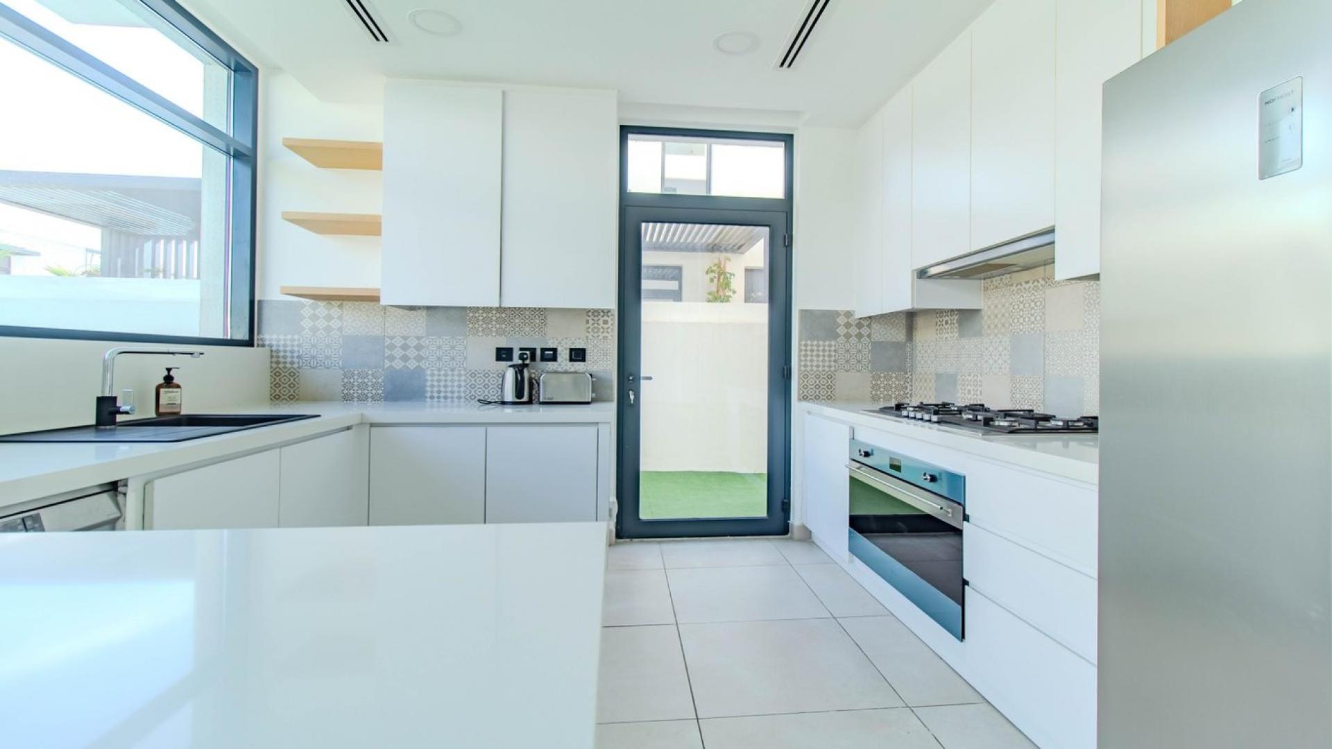 Bright, spacious living area in Jumeirah Golf Estates villa with large windows and garden view