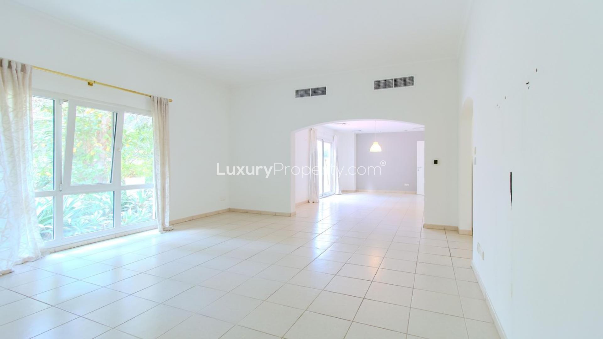 Empty living room with large window, tiled floor, and garden view in Meadows 9 villa