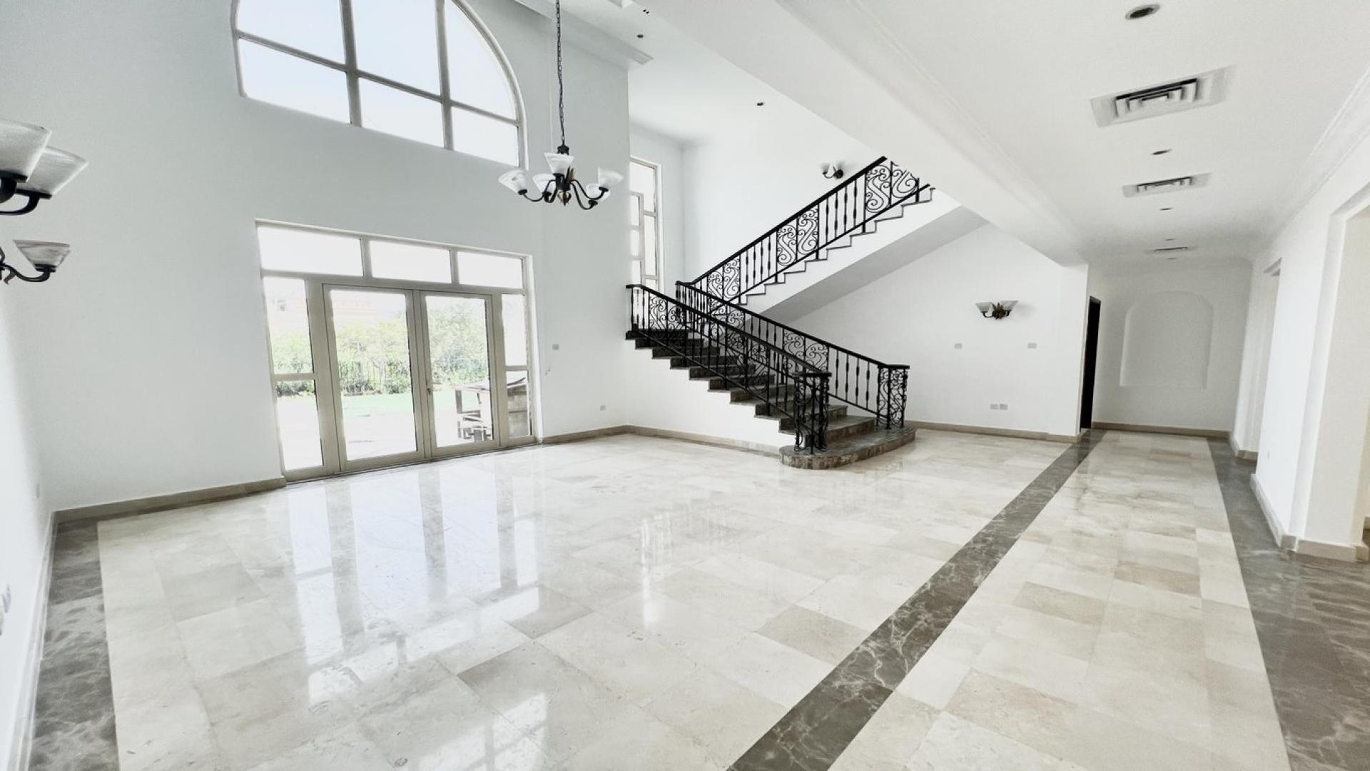 Luxurious Jumeirah Islands villa interior with elegant staircase and large windows.
