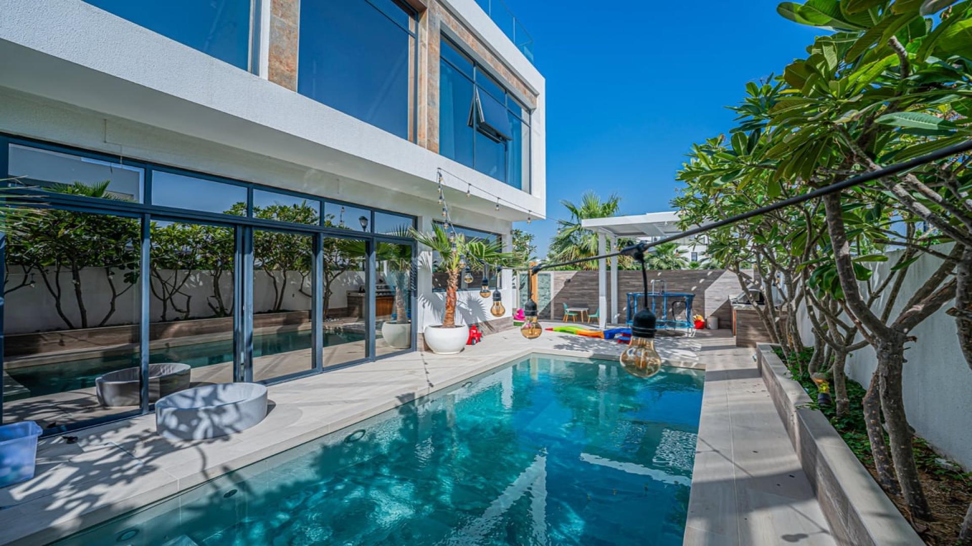 Contemporary villa interior with glass staircase and garden view in Jumeirah Luxury