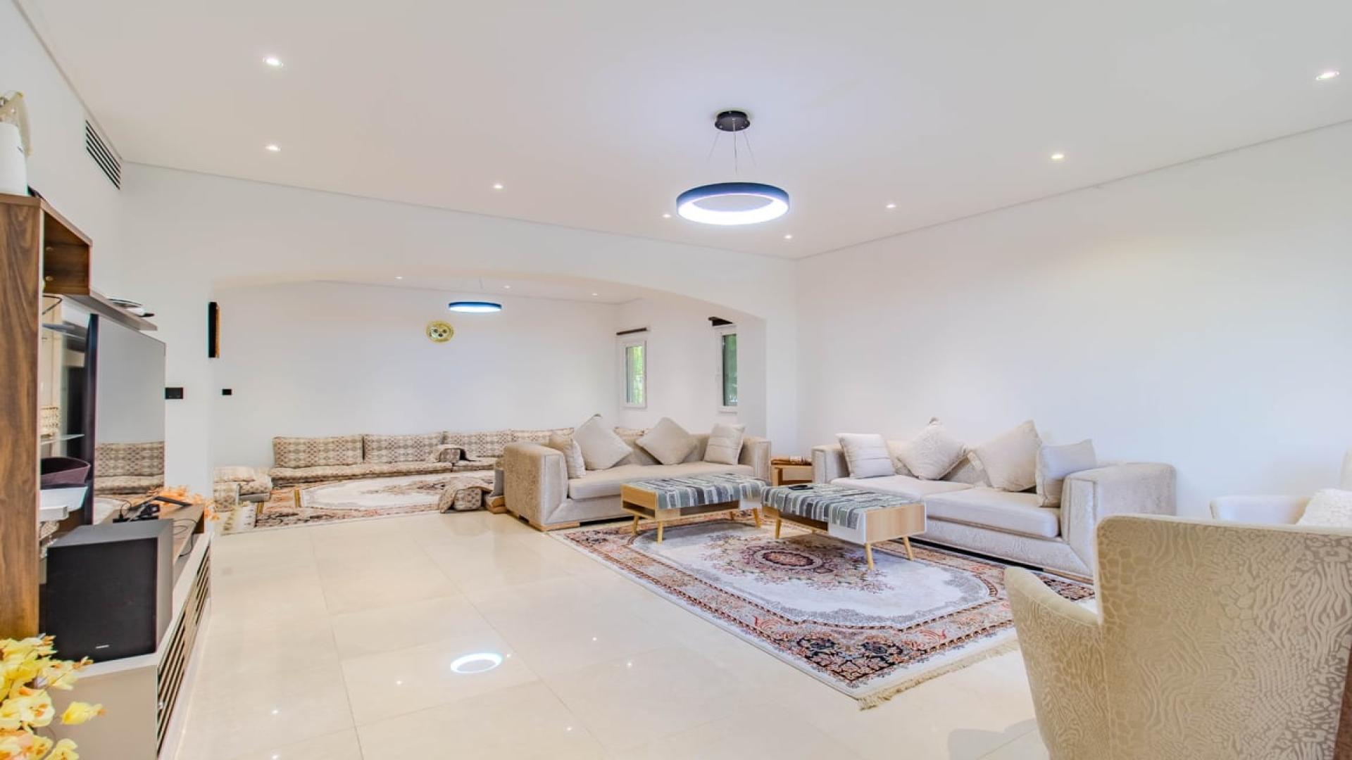 Spacious living room in 4-bedroom villa, Meadows 9, Dubai with modern decor and garden view