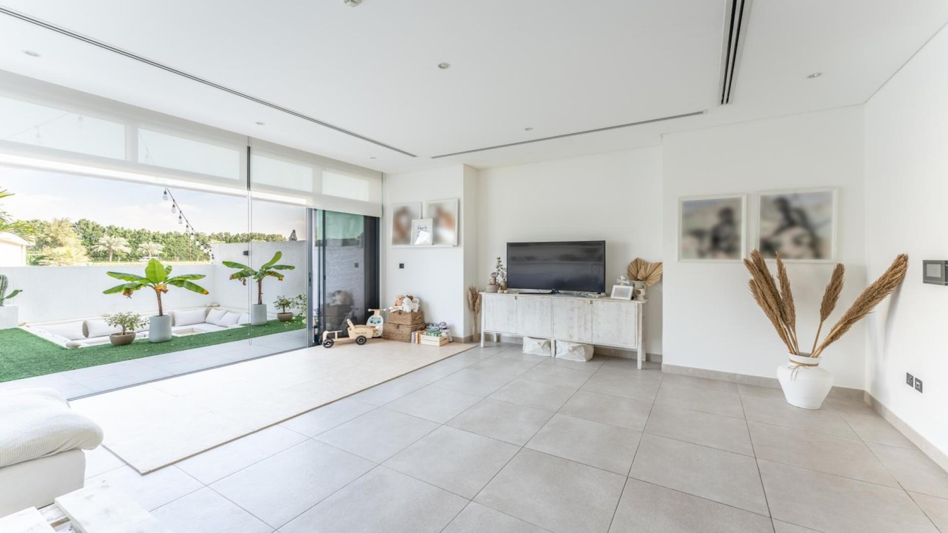 Bright living room in Jumeirah Luxury villa with large sofa and garden view