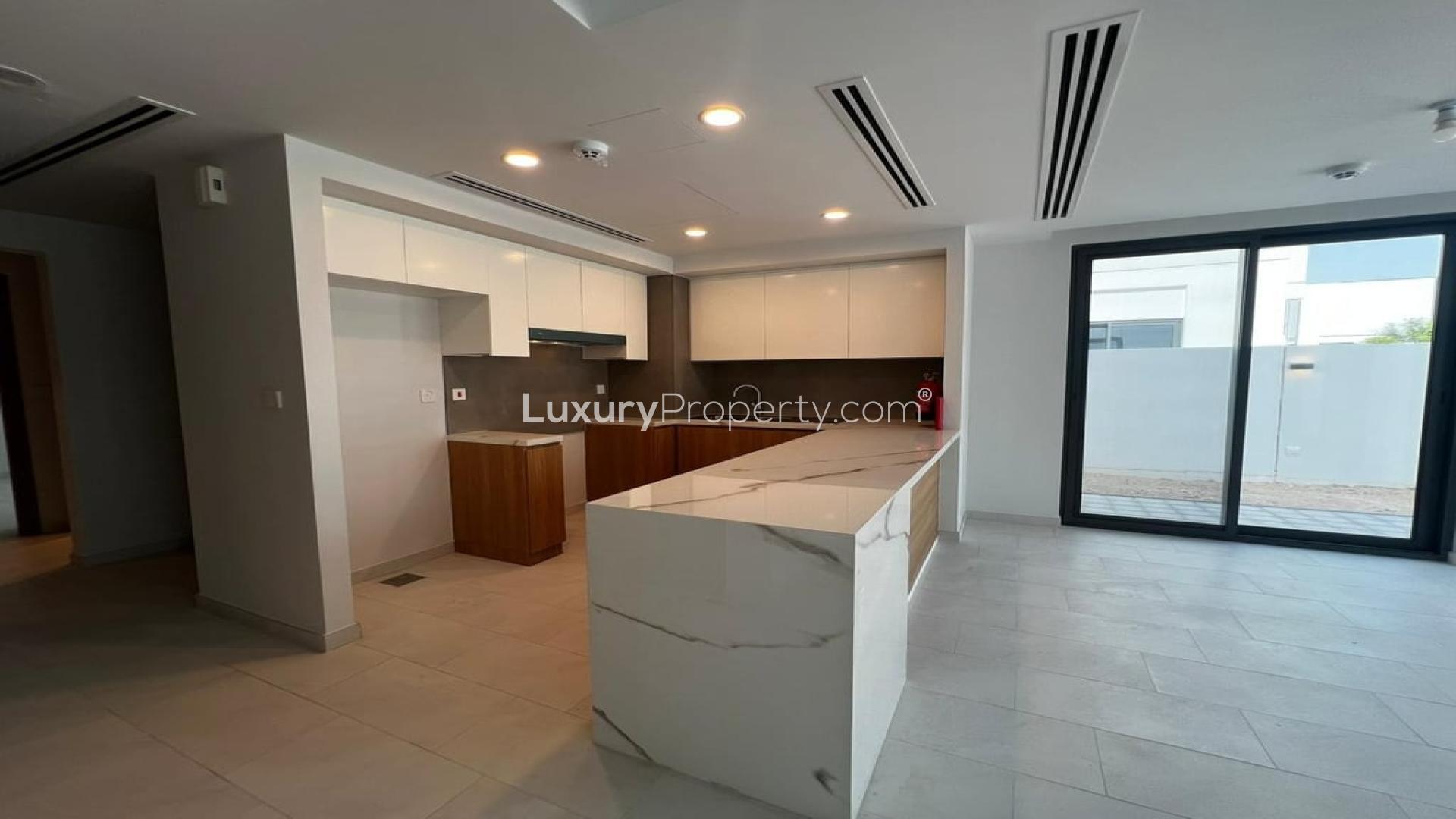 Modern open-plan kitchen and living area in Villanova villa, Dubai Land, available for rent