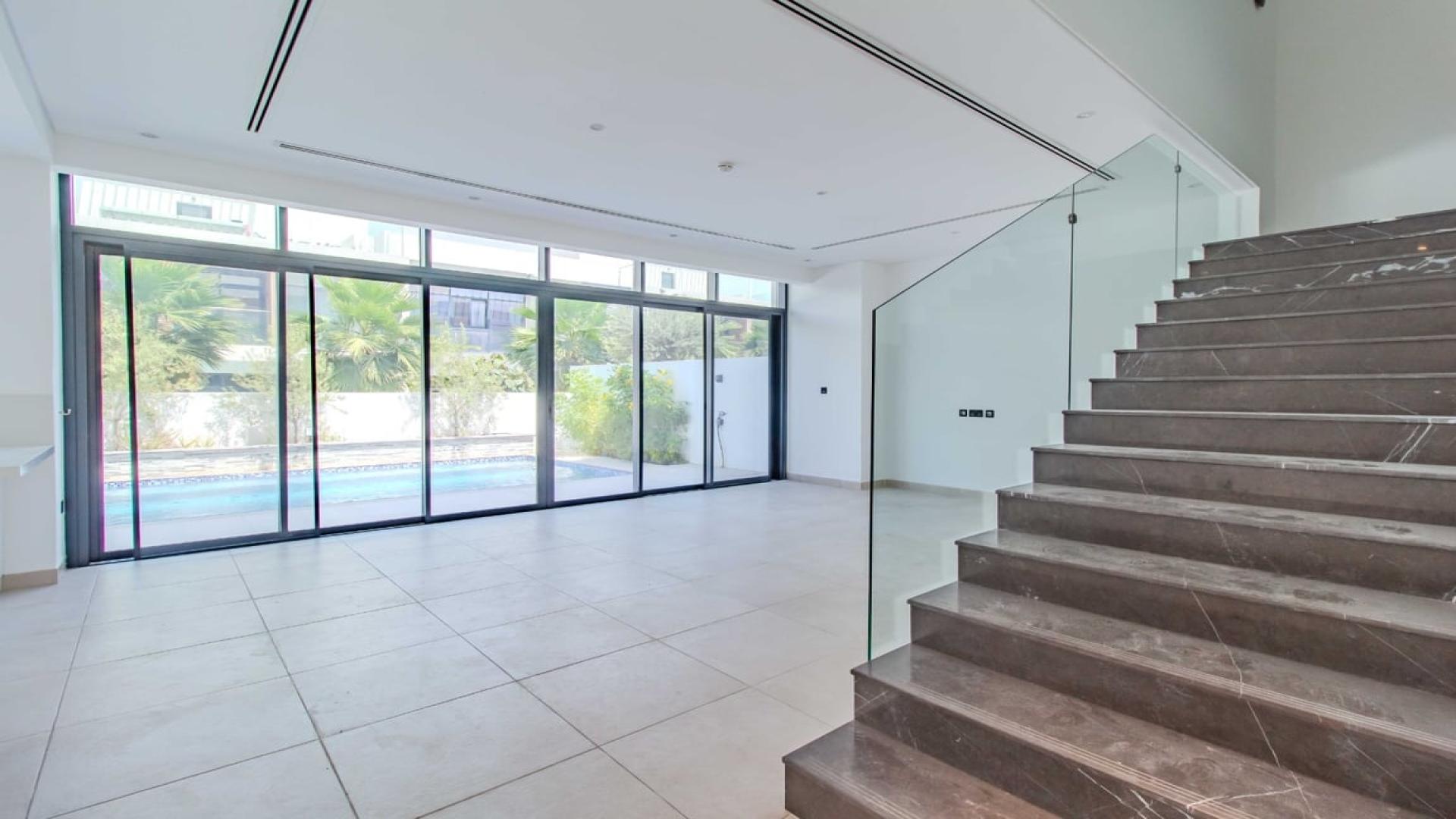 Modern kitchen and living area with pool view in Jumeirah Golf Estates villa