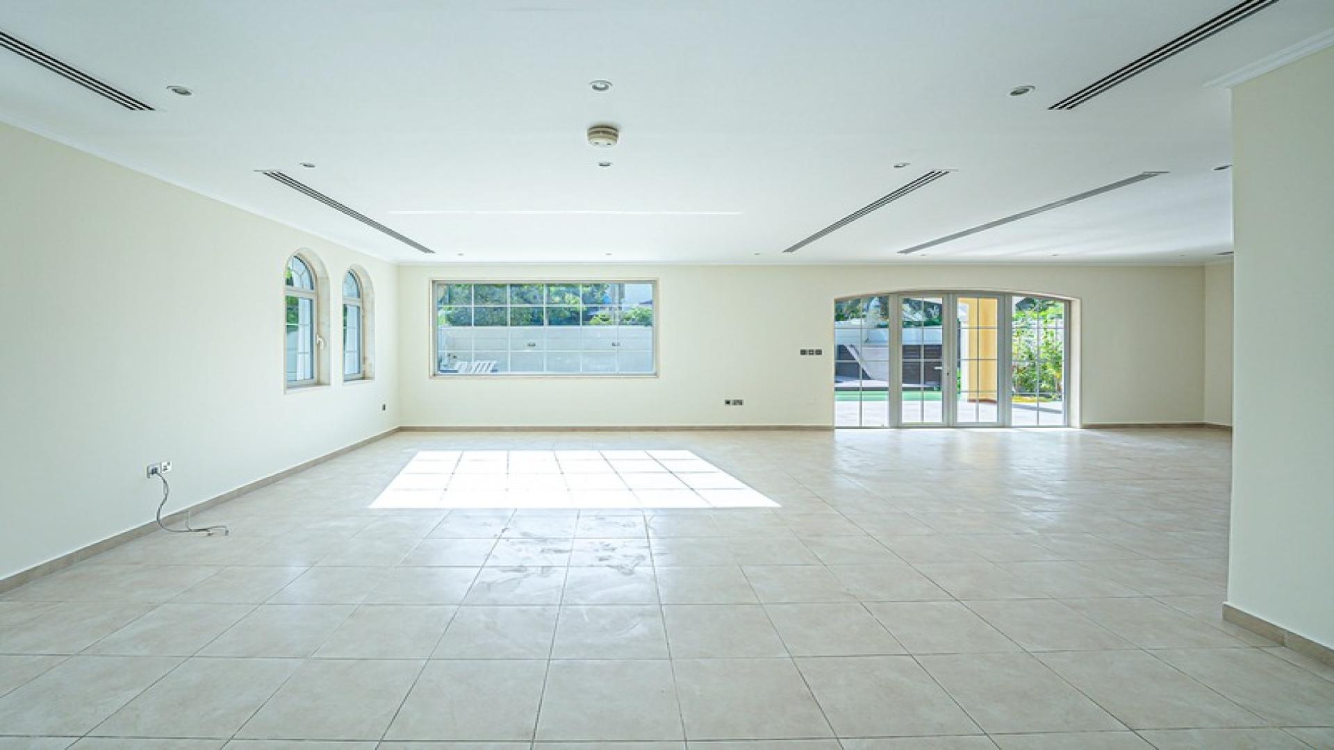 Spacious living room in Jumeirah Park villa, tiled floor, natural light, large windows