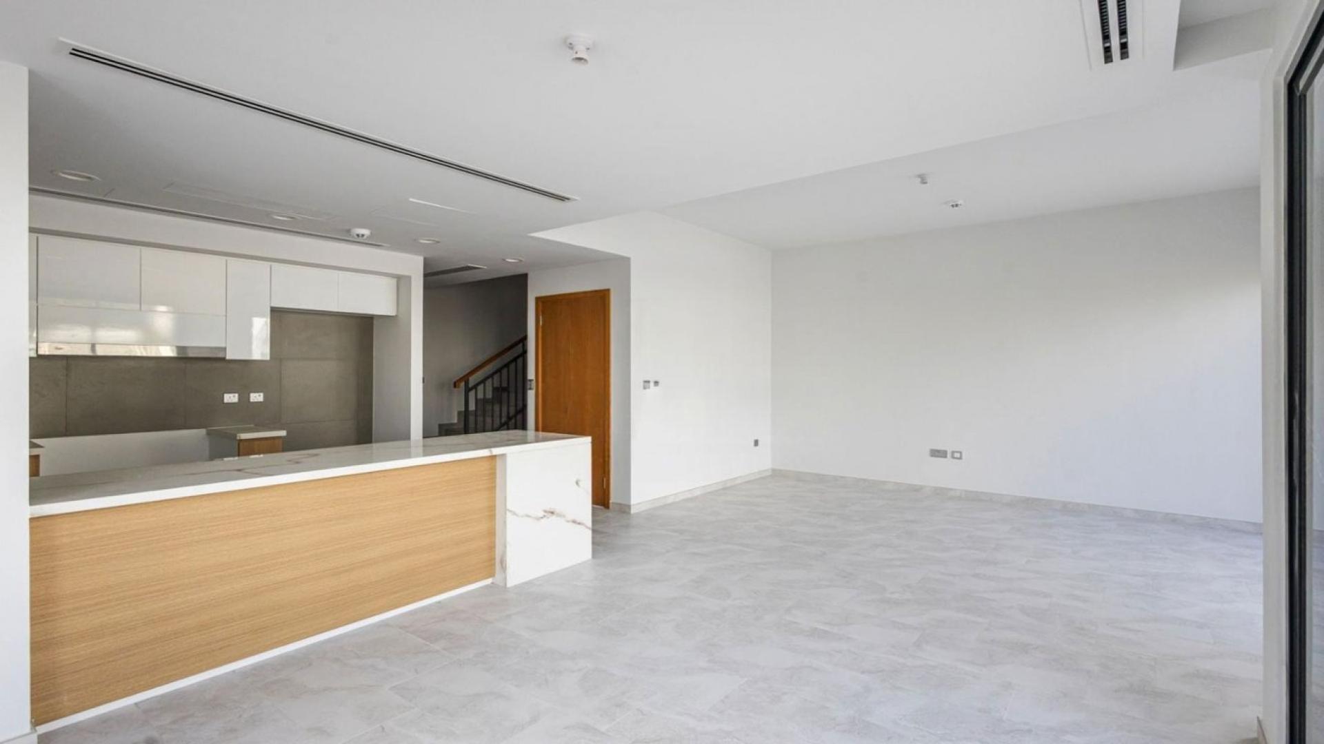 Modern open-plan kitchen and living area in Villanova villa, Dubai Land, for rent